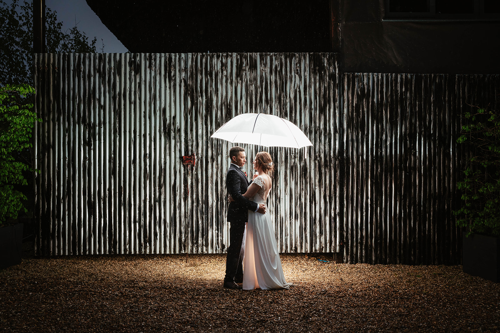 nighttime portraits of bride and groom in the rain