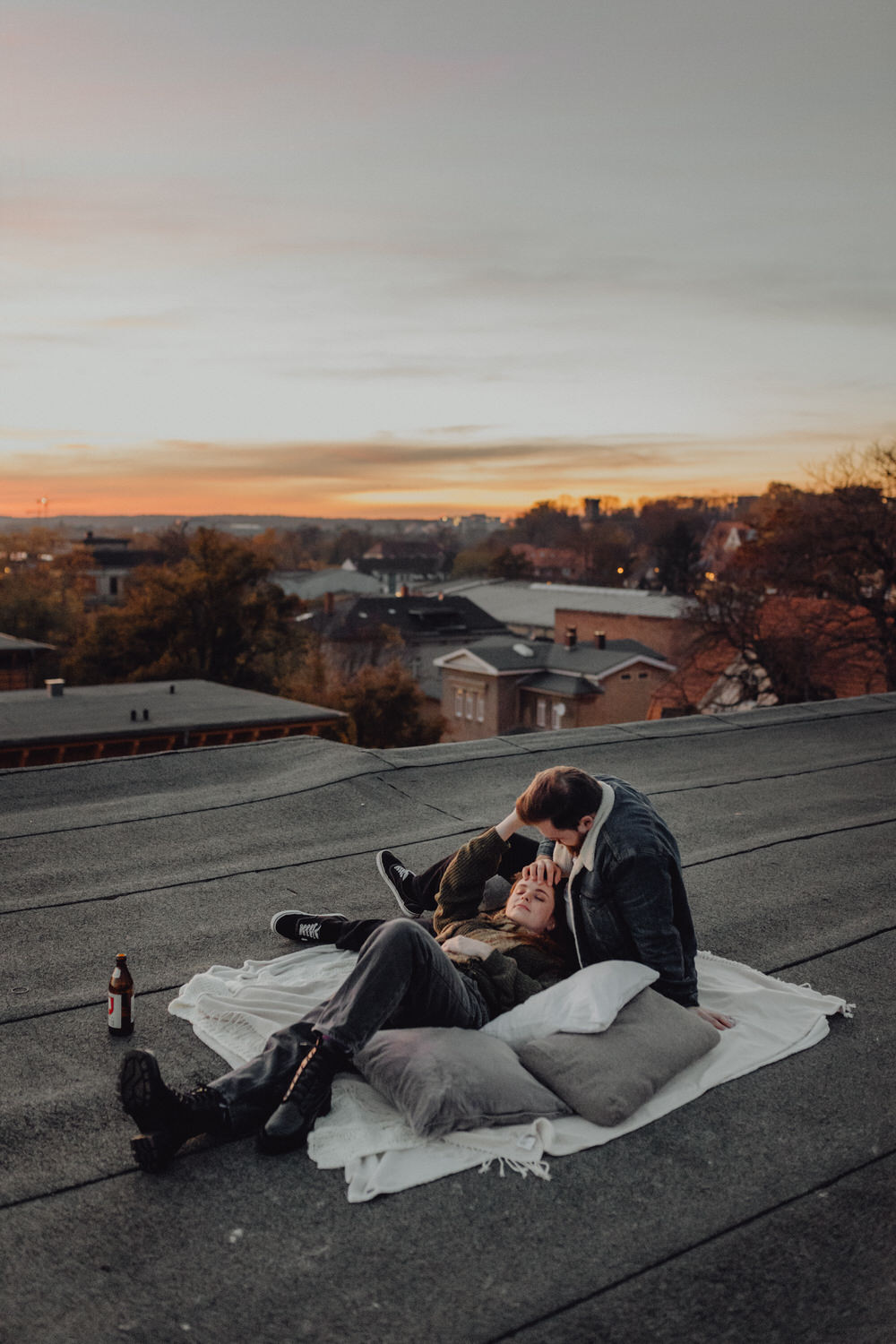 Paar kuschelt bei blauer Stunde auf dem Dach