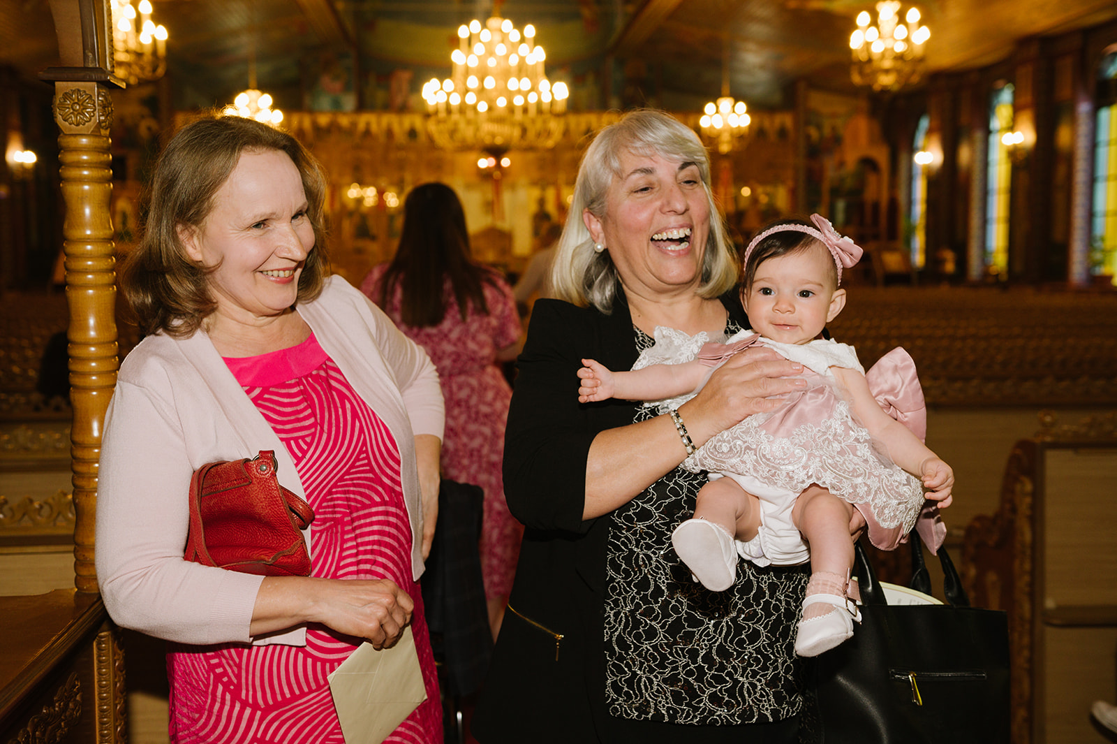 baby girl with her grandmas in the church for her christening