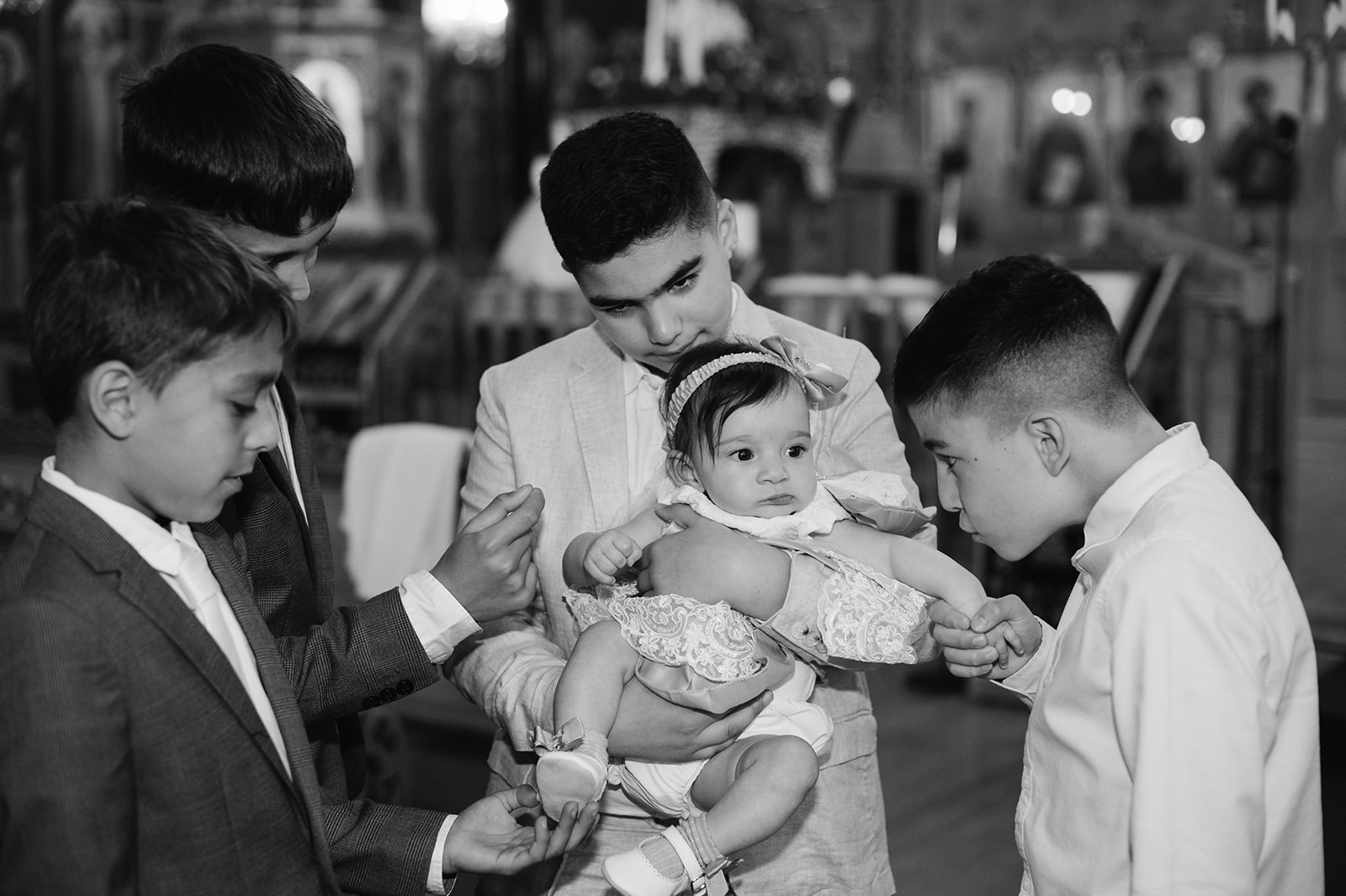 little boys holding the baby girl for her christening