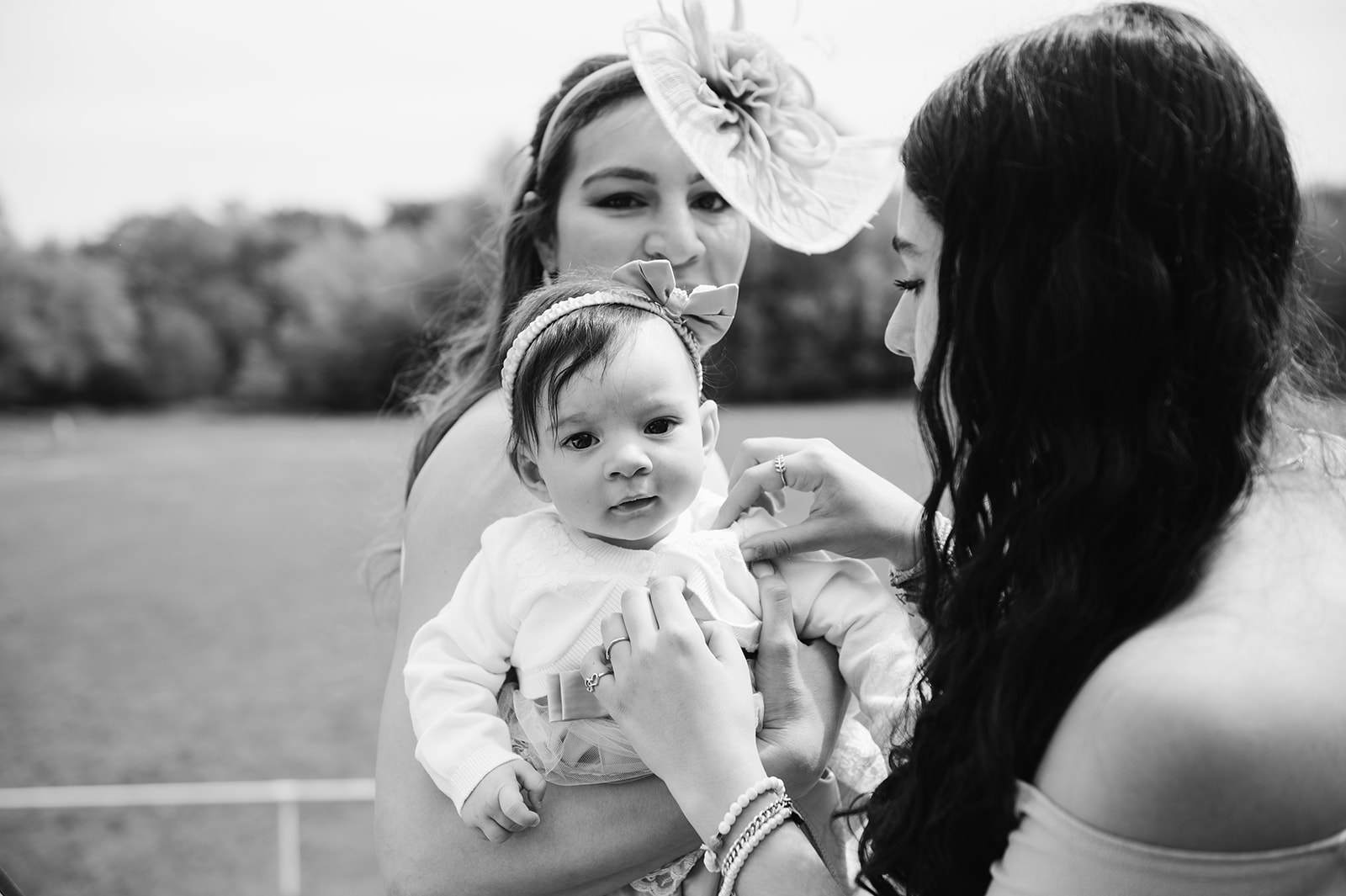 woman holding baby girl in a dress in black and white