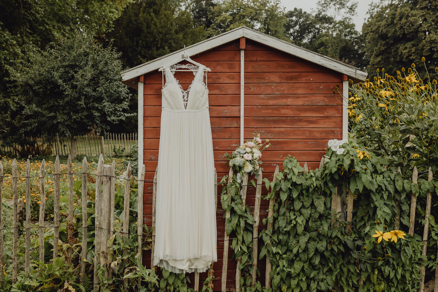 Detailbild vom Brautkleid und Brautstrauß im Garten beim getting Ready