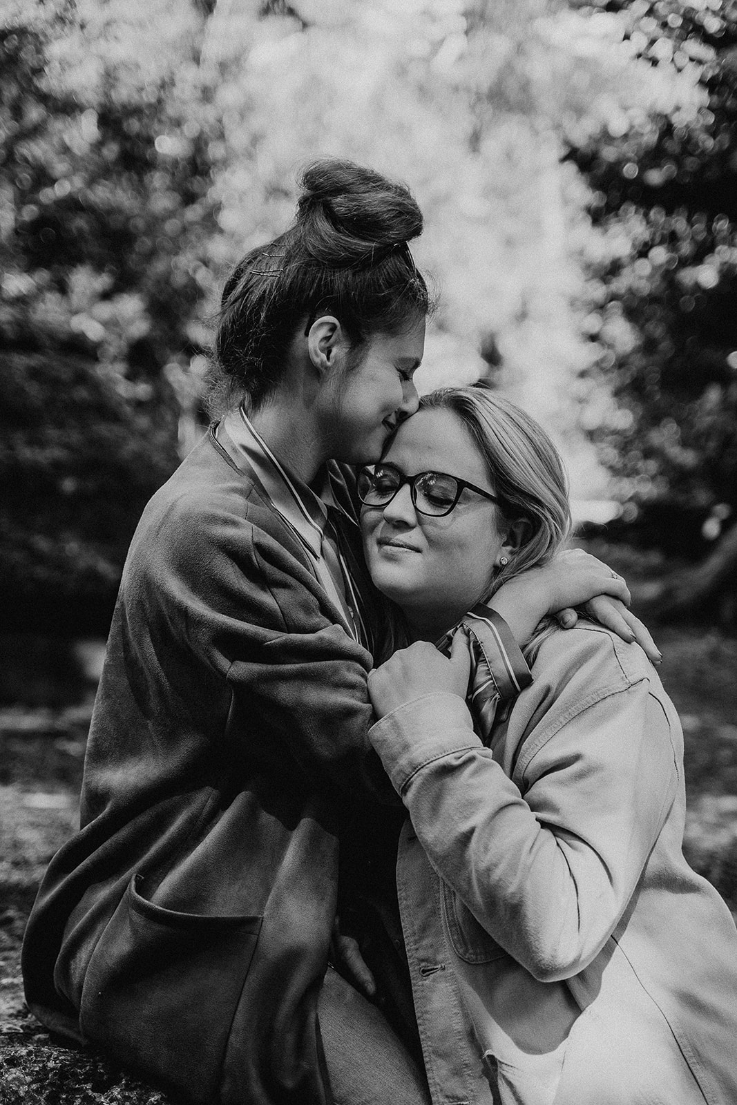 black and white photo of female same-sex couple cuddling together in a park in Southampton 