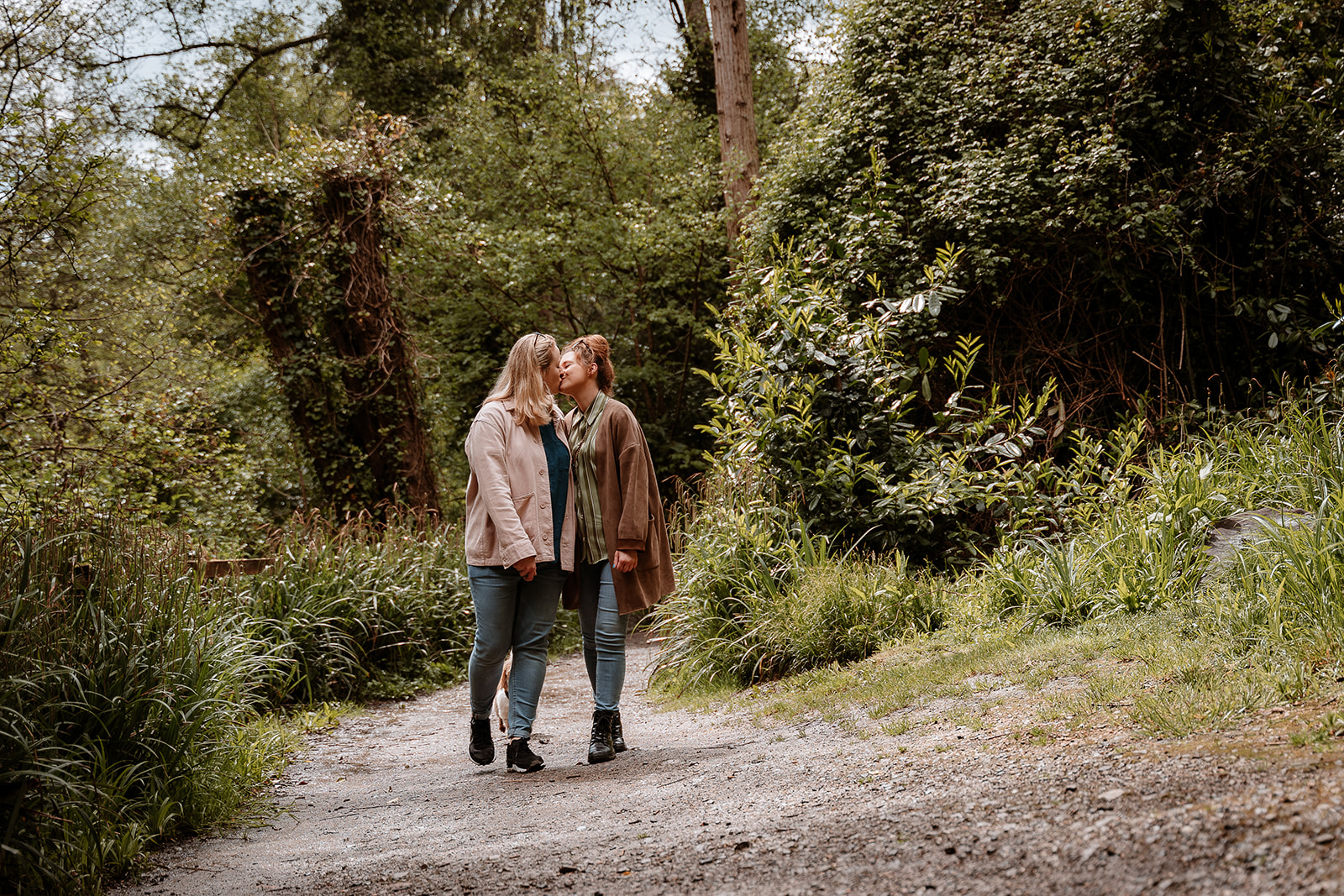 couple walk hand in hand together along a woodland path - couples photography Southampton 