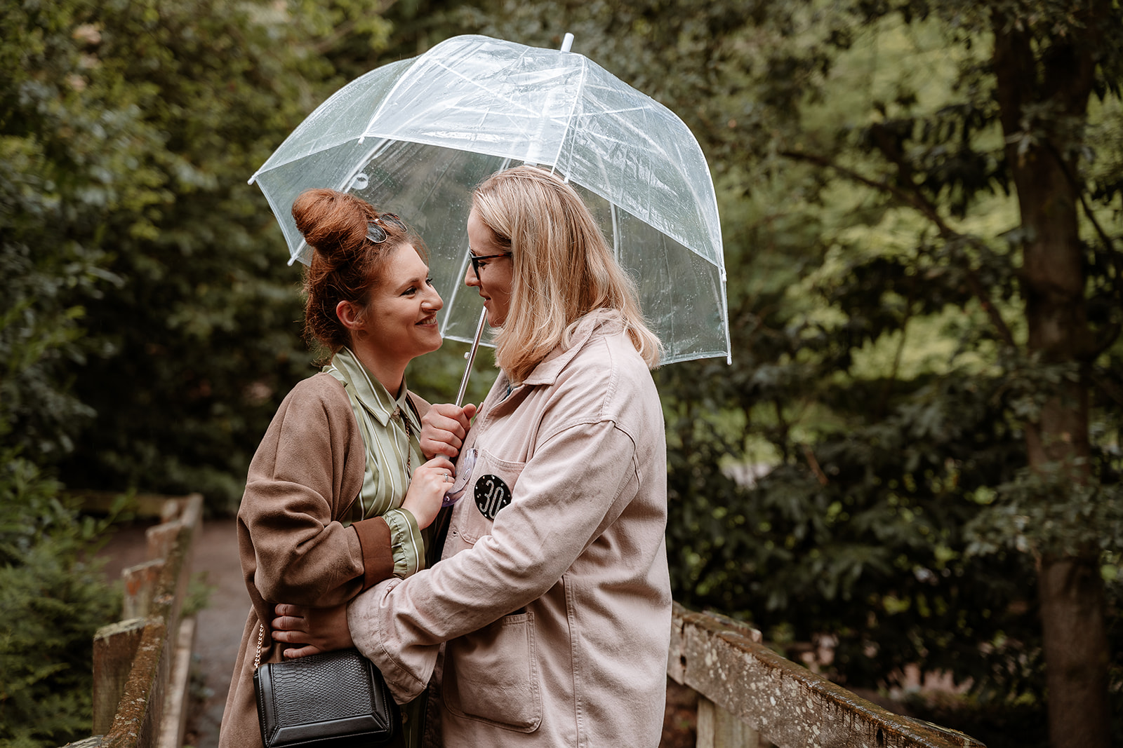 female couple snuggle together under an umbrella - couples photoshoot southampton