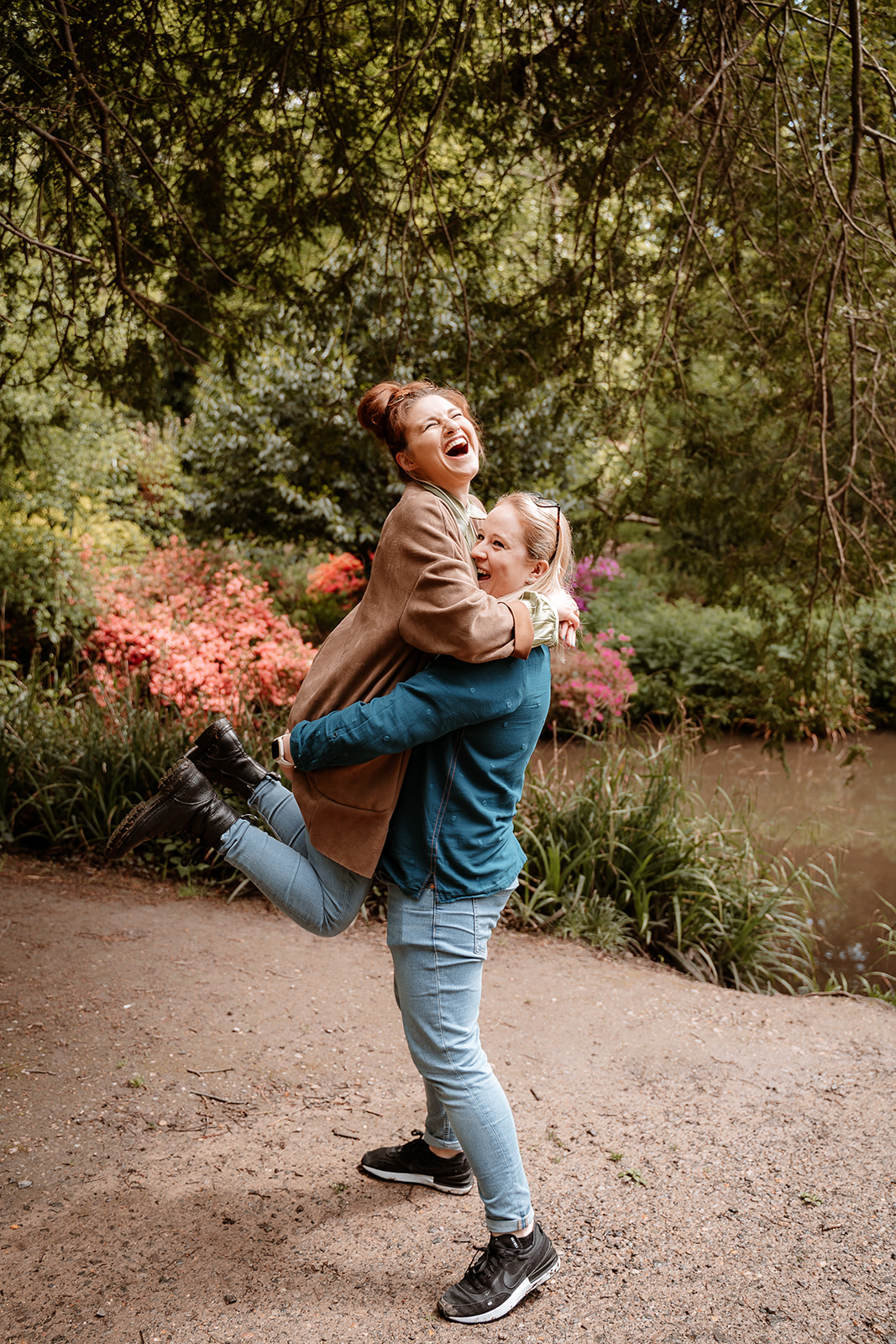 woman lifts her fiancee and they laugh together on their couples photoshoot in Southampton