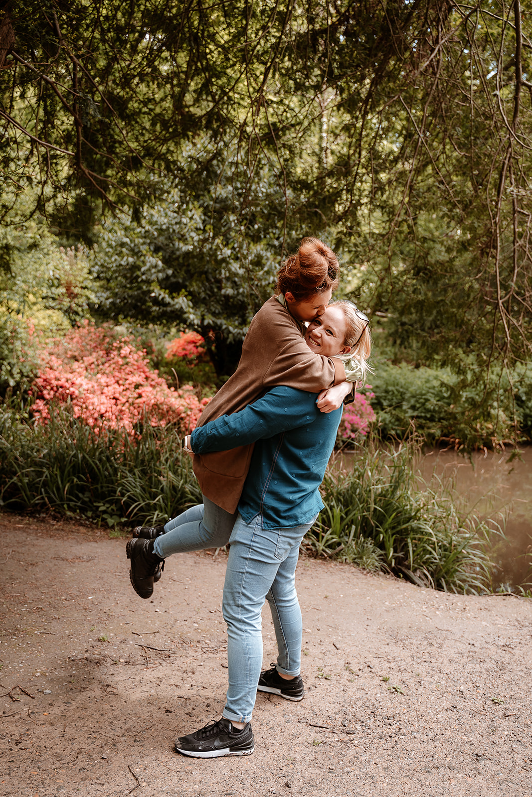 woman lifts her fiancee and they laugh together on their couples photoshoot in Southampton