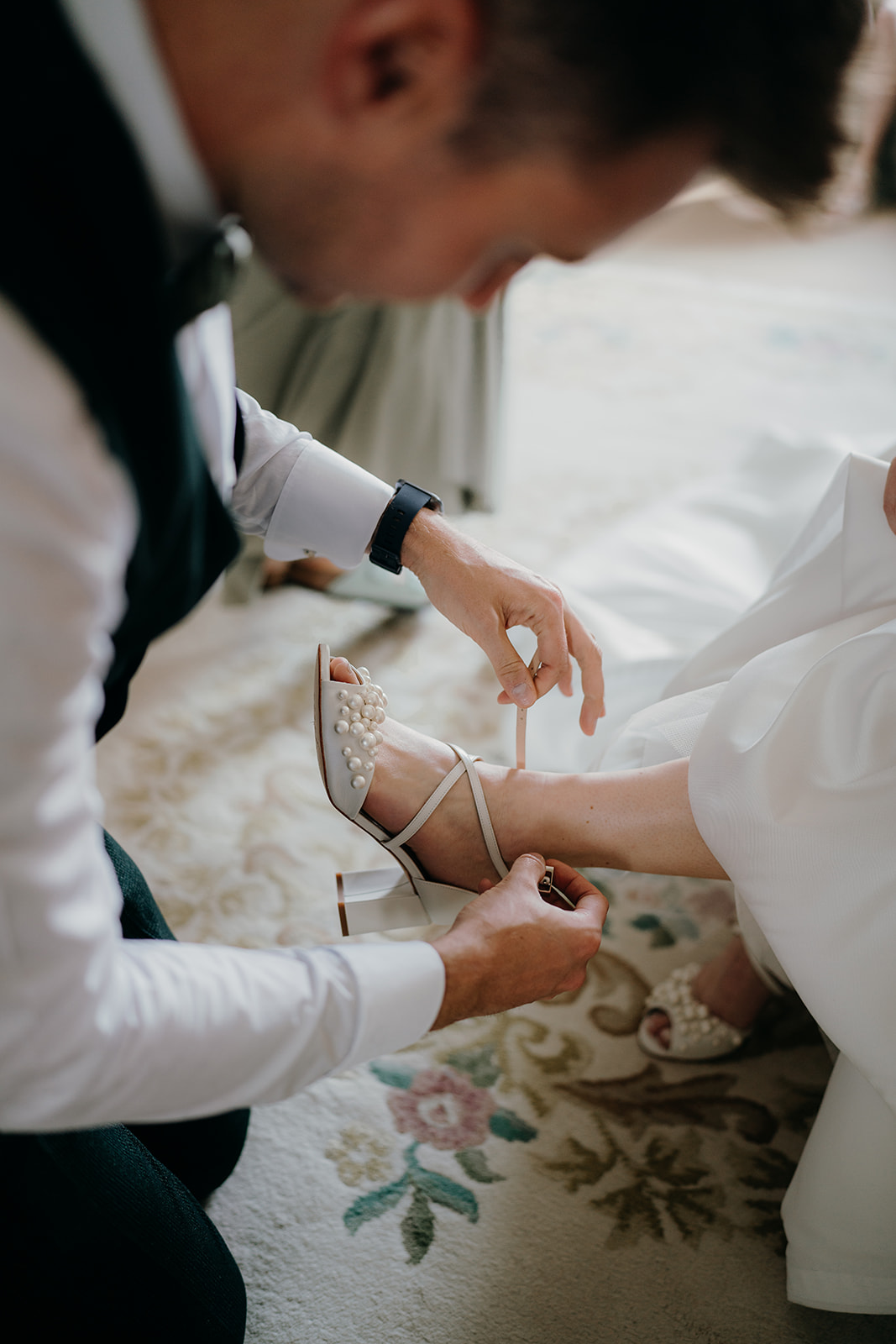 Close up of Brides brother putting on her Charlotte mills shoes
