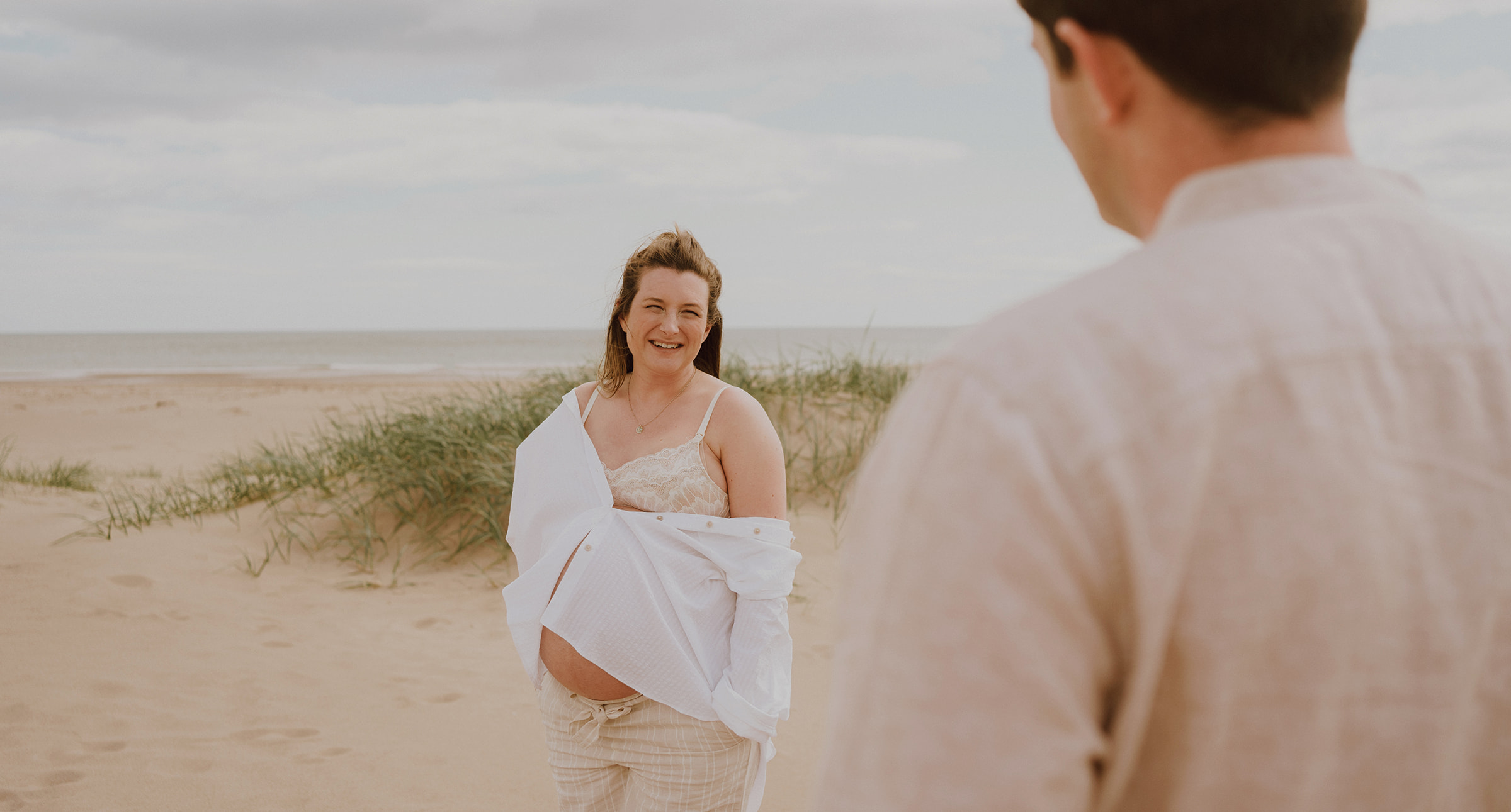 Pregnant lady smiles at her husband during maternity photoshoot