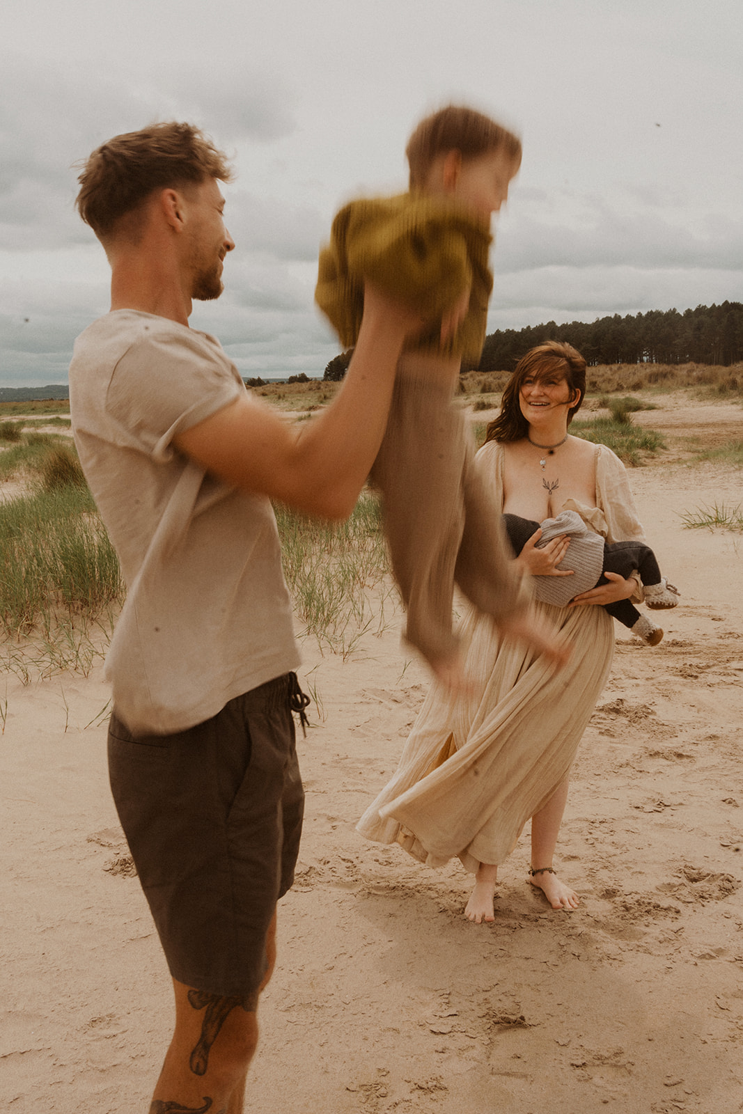 Dad plays with toddler during family photoshoot at Tentsmuir, Fife, Scotland