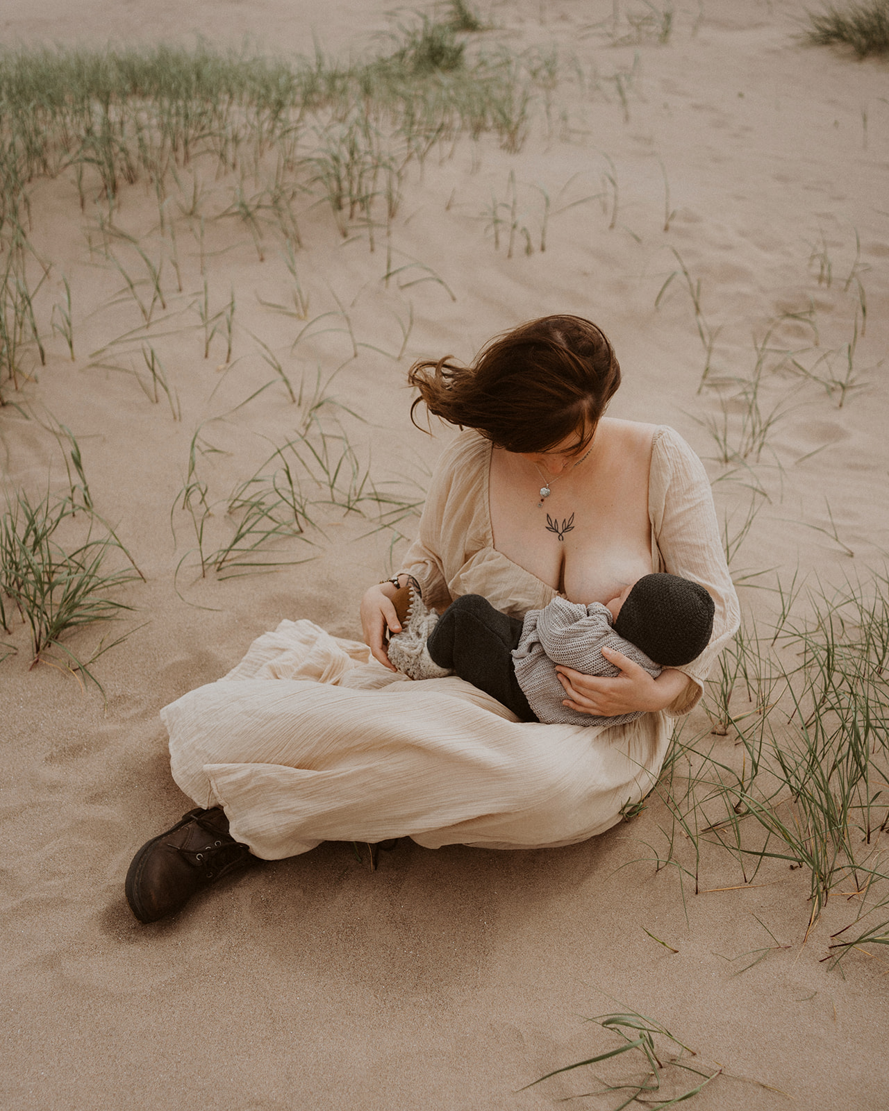 Mother breastfeeds newborn baby during family photoshoot on the beach at Tentsmuir, Scotland