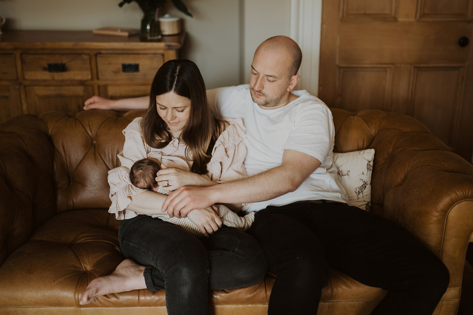 Family cuddle on the sofa during newborn family shoot in Edinburgh