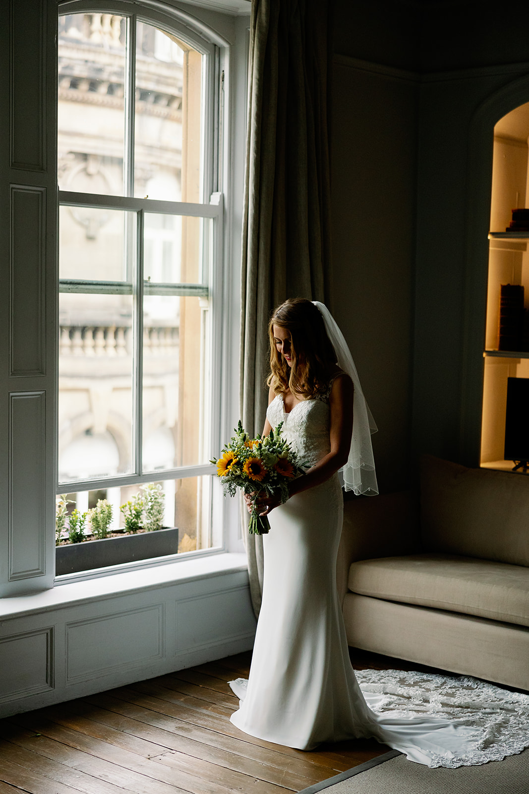 A bride portrait in front of a big window in the bridal prep 