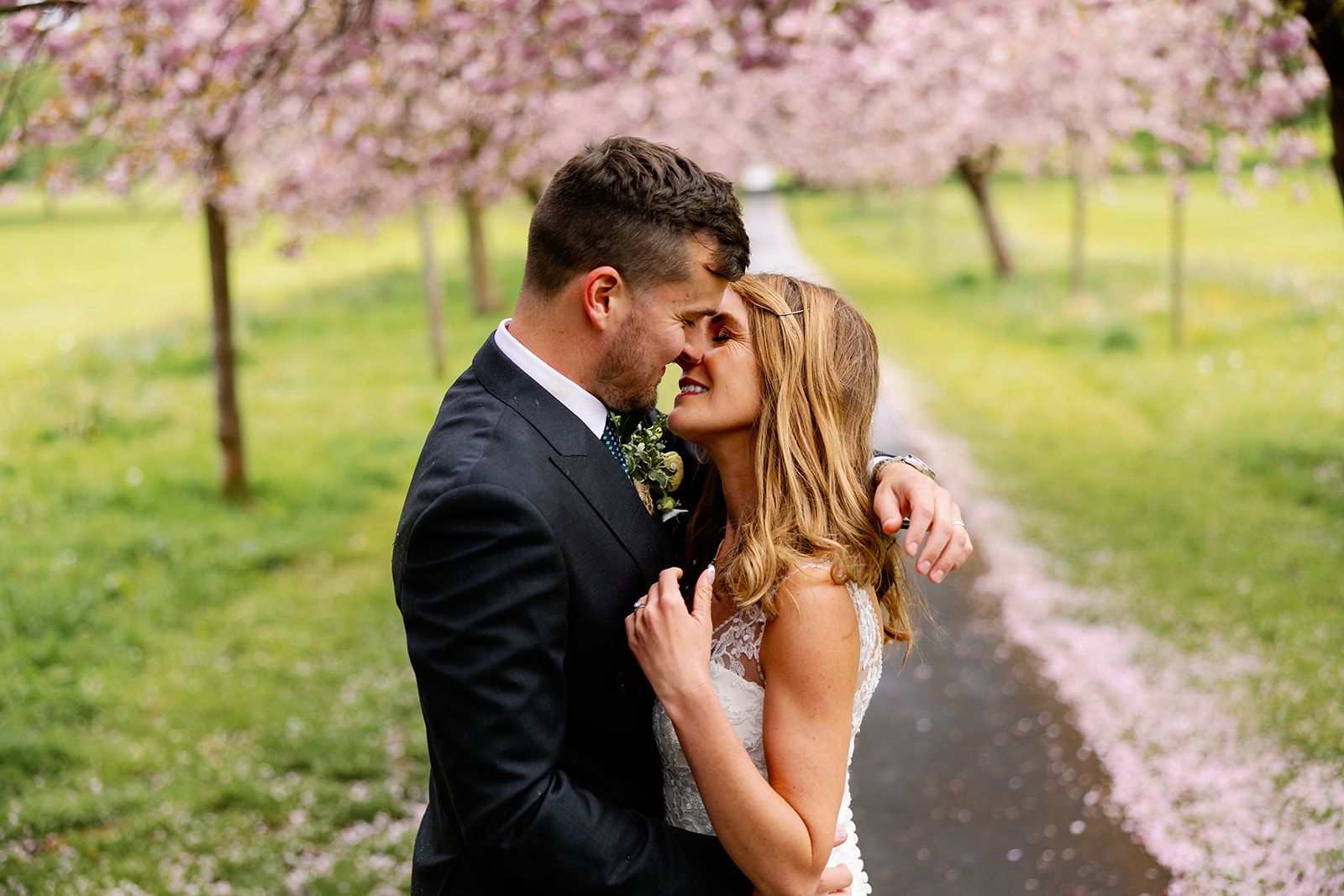 A very romantic picture of a bride and groom kissing under the cherry blossom 