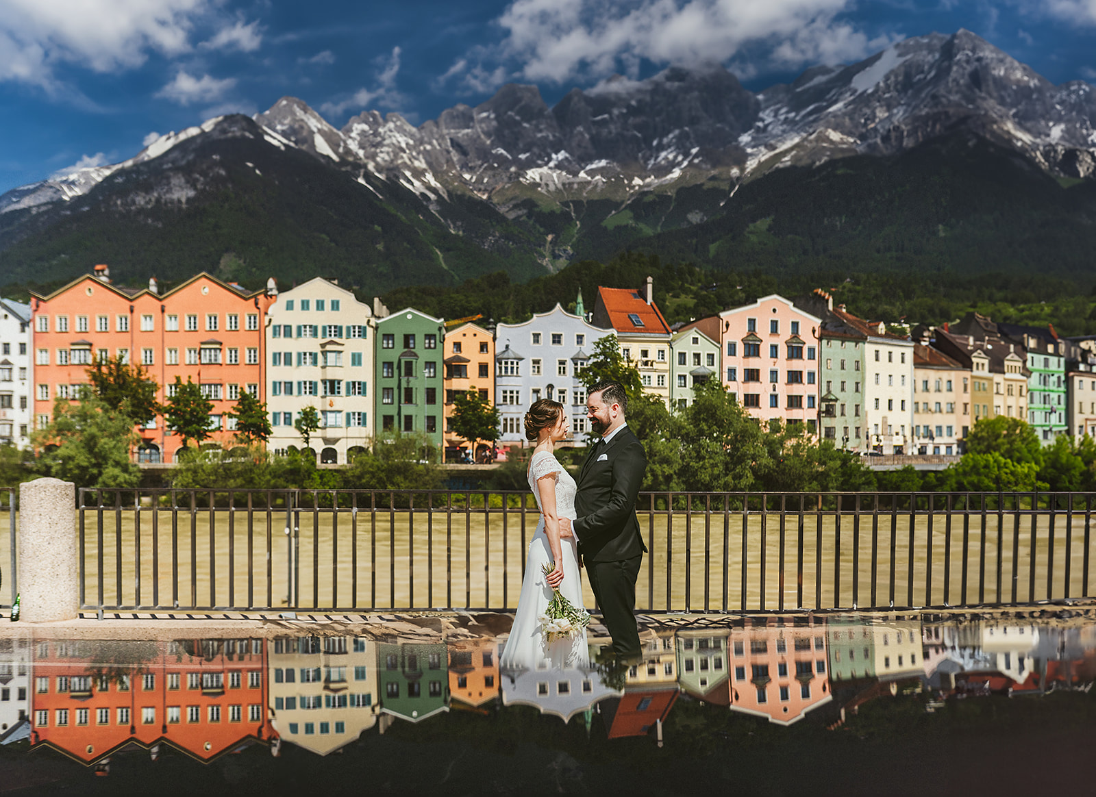 A bride and groom in front of colorful houses in the city of Innsbruck in the Tyrol