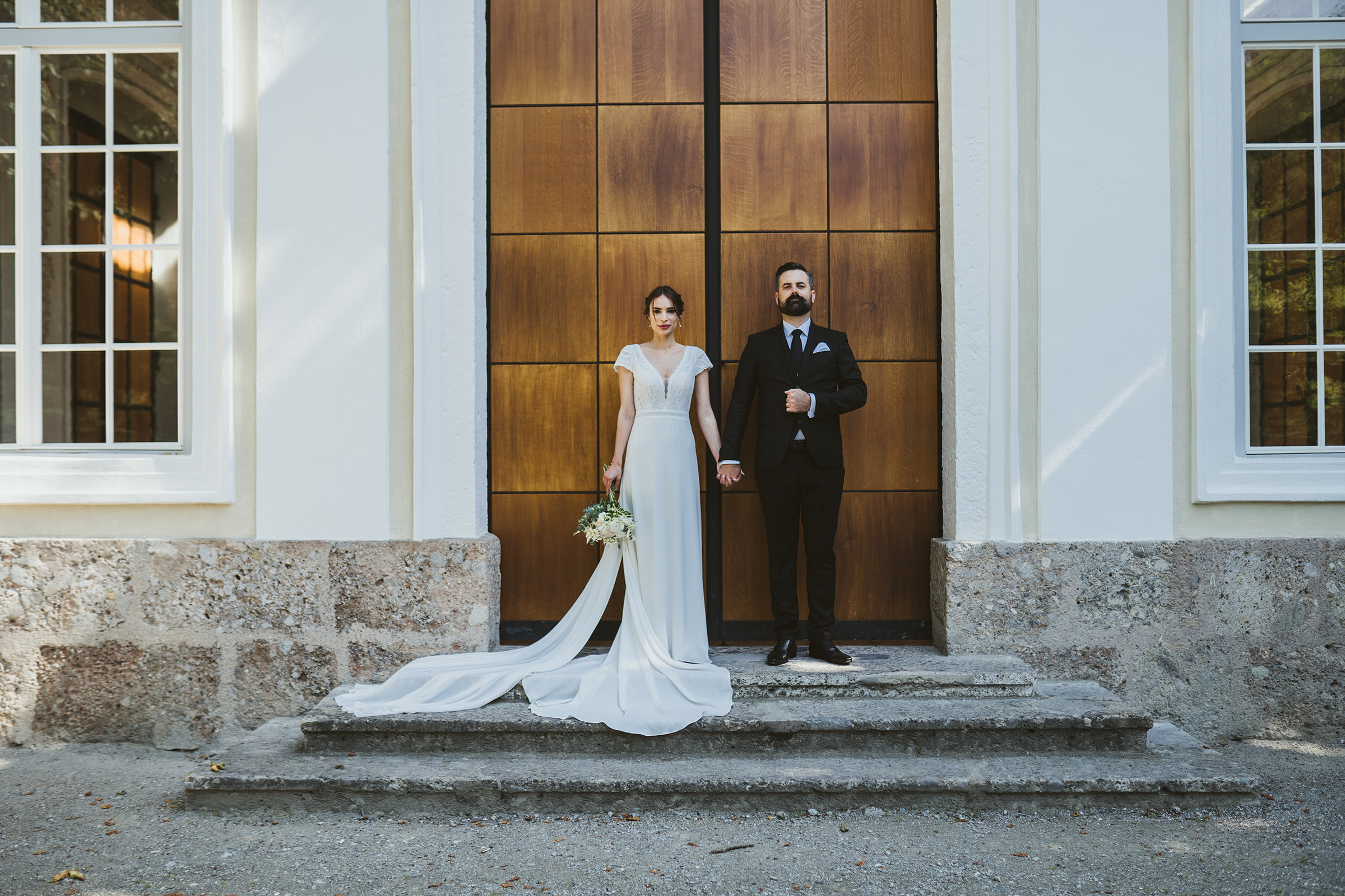 A bride and groom in the hipster pose in front of the music pavilion in the Hofgarten in Innsbruck