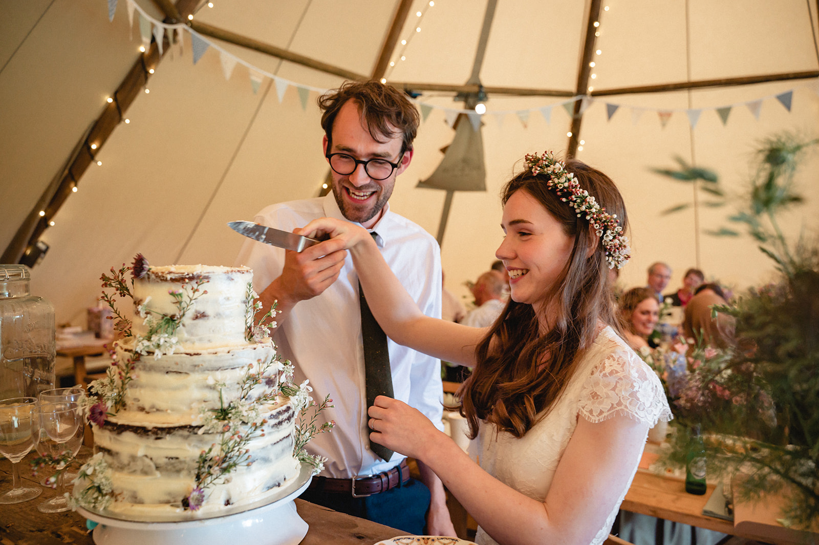 Candid portrait of Eleanor & Hartley slicing the cake wedding reception at St. Paul's Walden Bury 