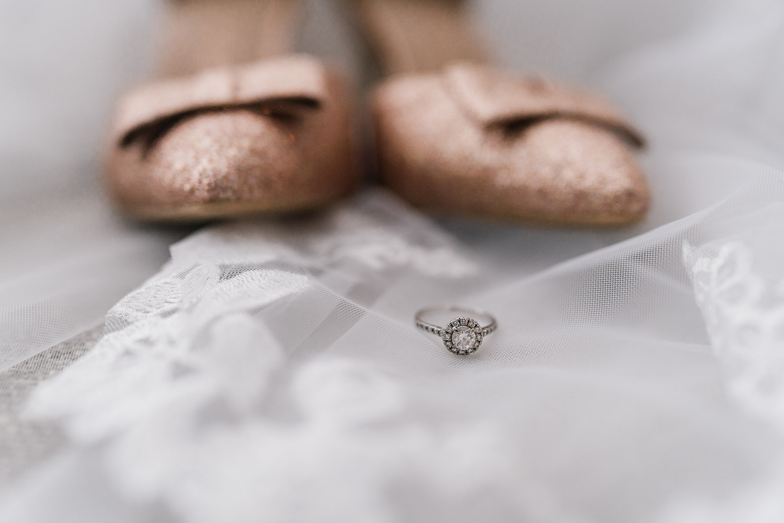 Wedding ring in front of wedding shoes