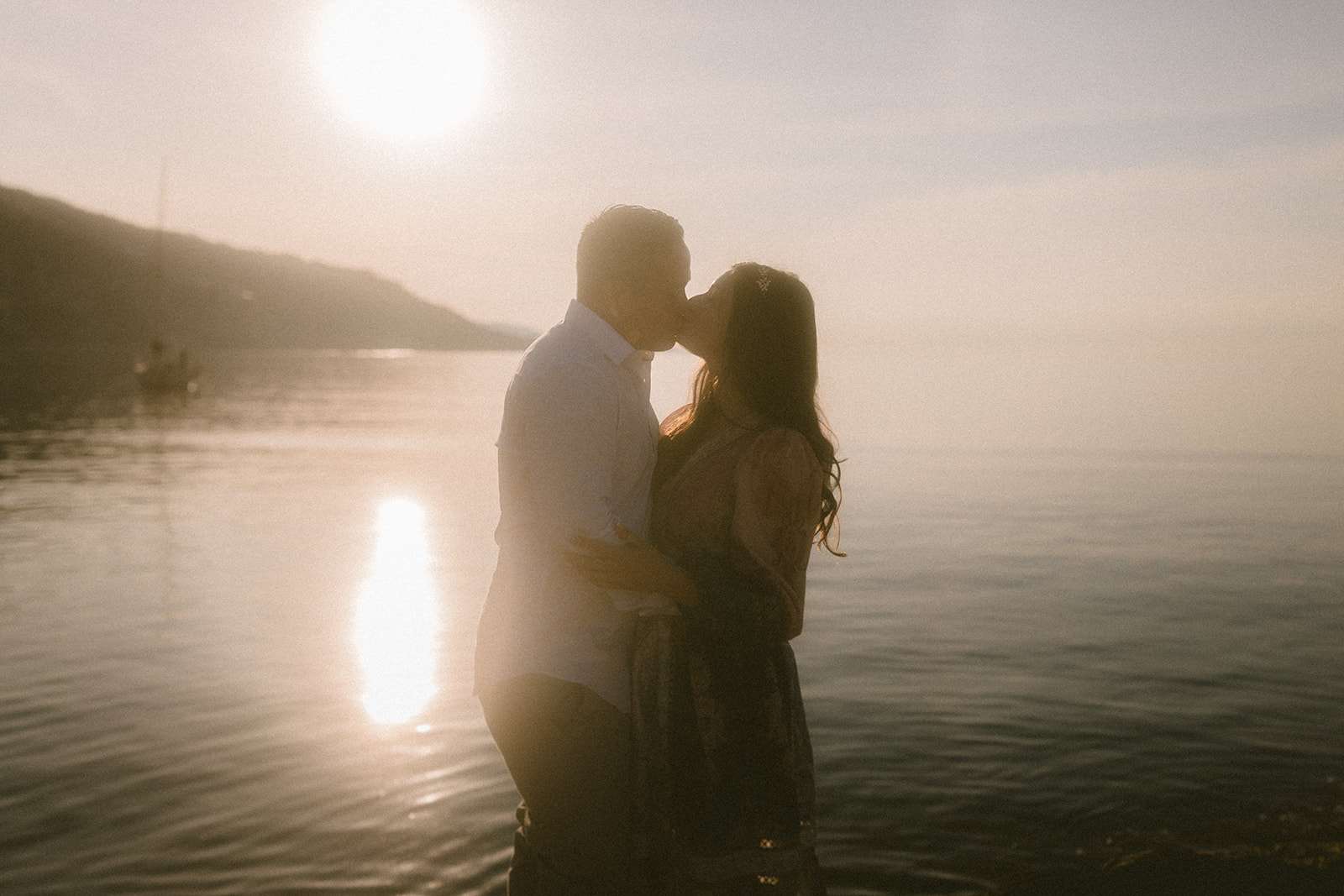 photo of a couple kissing at sunrise