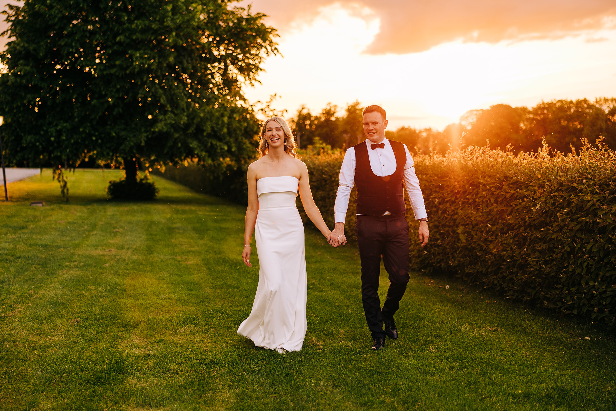 Bride and groom in castle durrow grounds with a sunset behind them