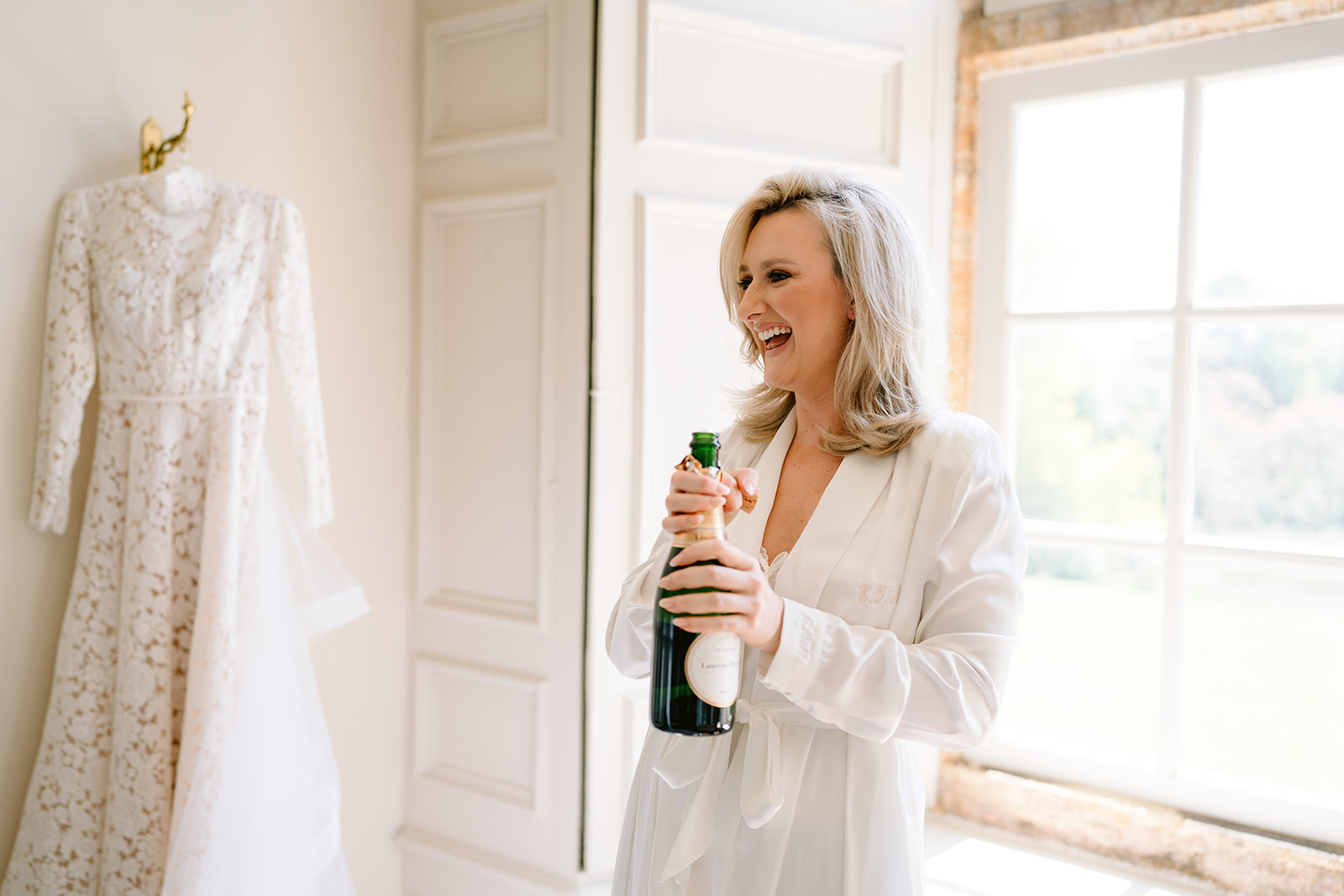 bride opening a bottle of champagne
