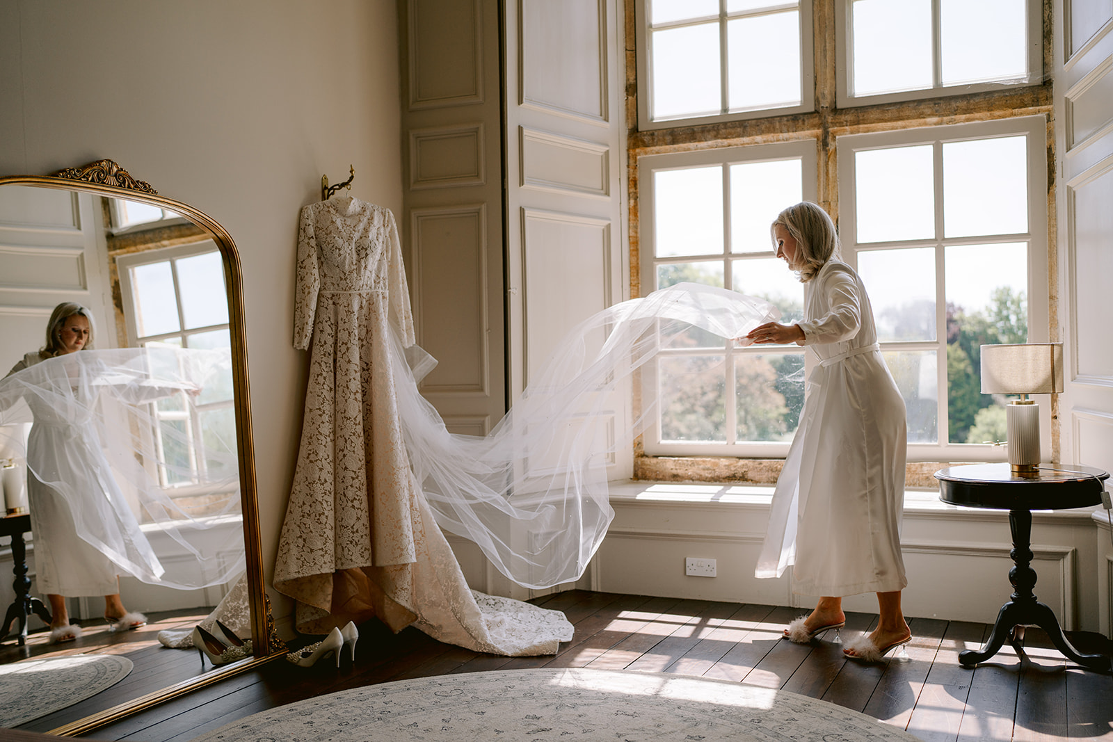 bride playing with a veil in bridal suite