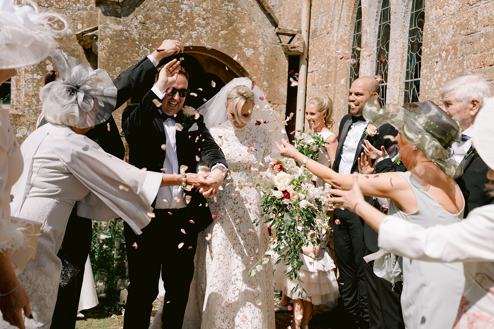 confetti being thrown at the bride and groom outside st andrews chapel on a sunny day
