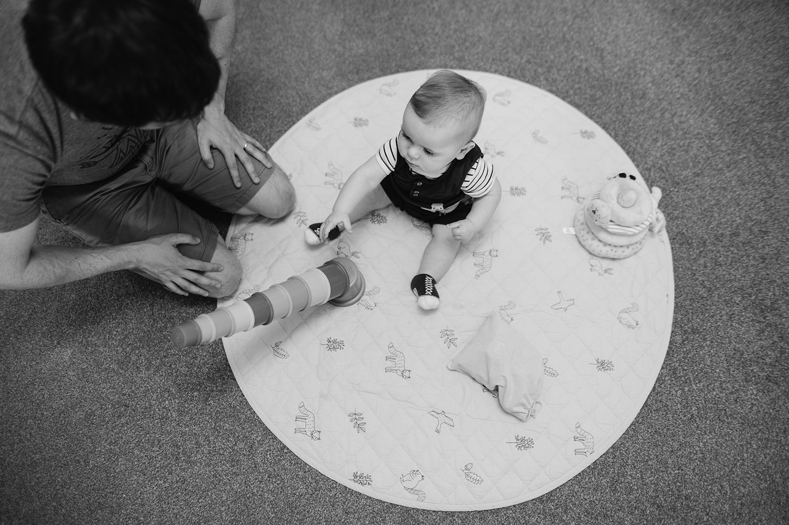 baby boy on playmat knocking over tower