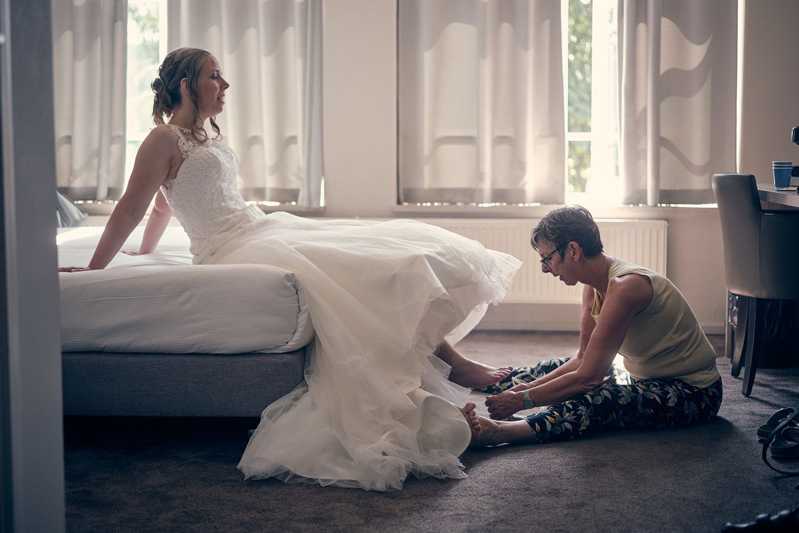 Trouwshoot bruidsfotografie Hotel Fletcher Deurne met Mike en Ilja - schoenen aantrekken bruid