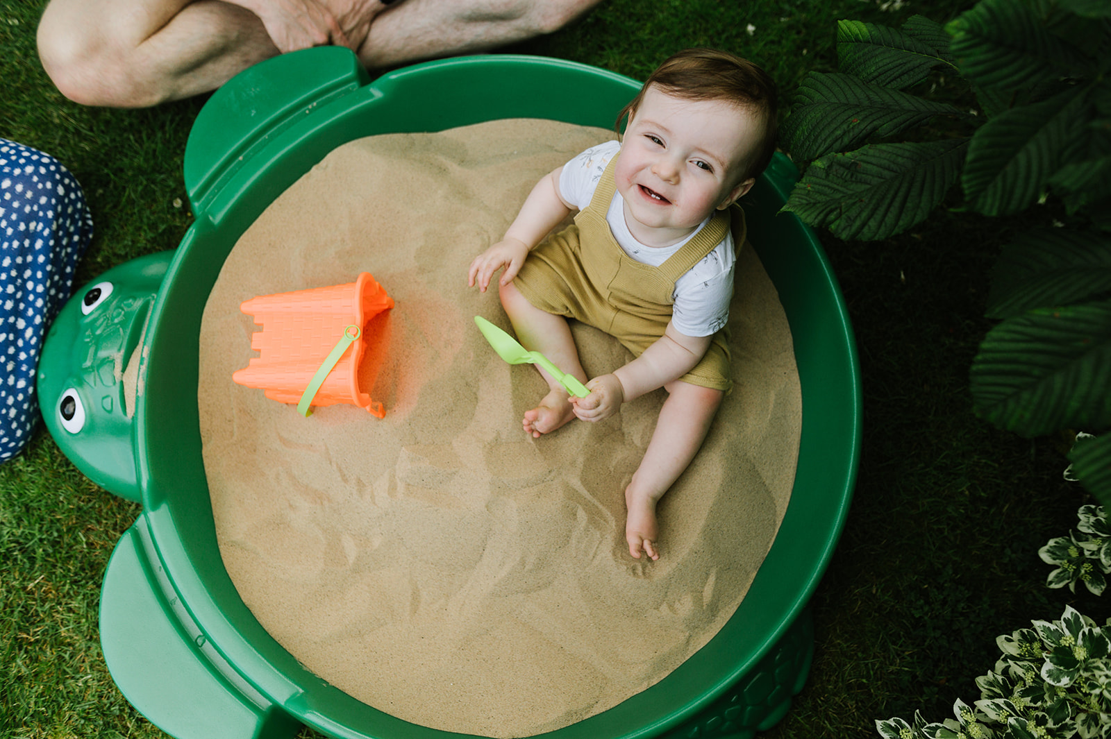 birds eye view of a one year old boy in his brand new sandpit 