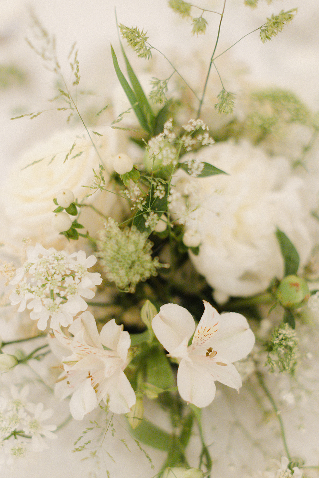 Tischgesteck aus weißen Blumen mit Grün