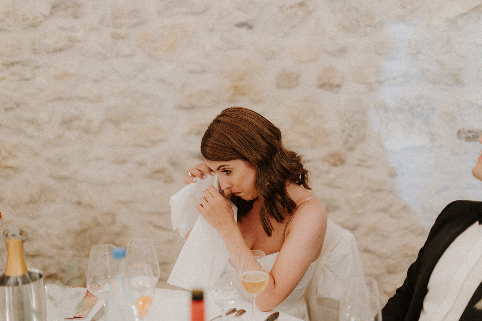 Braut tupft sich Tränen mit Stoffserviette ab