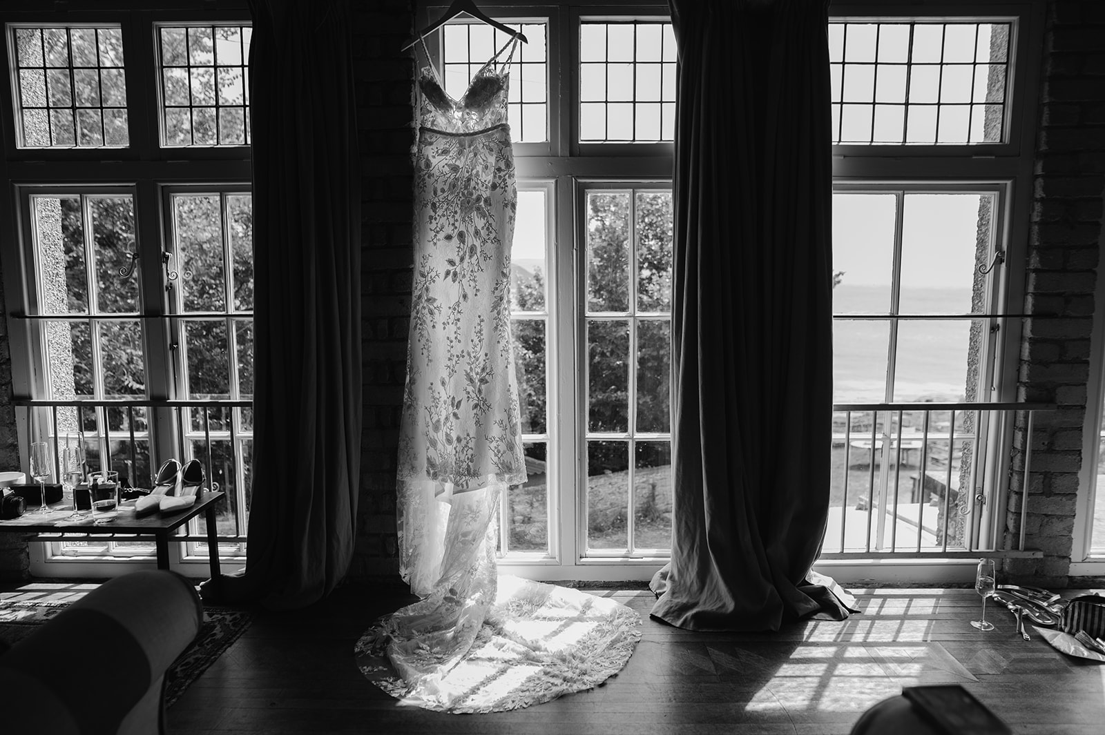 wedding dress hanging in the window backlit by the sun