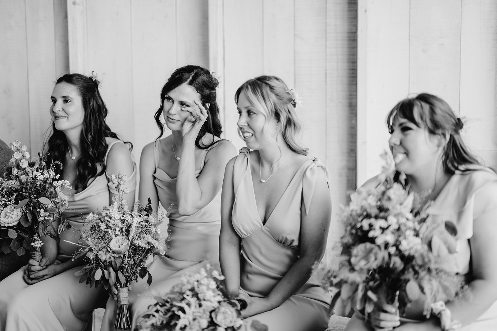 a black and white photo of bridesmaids being emotional during romantic ceremony