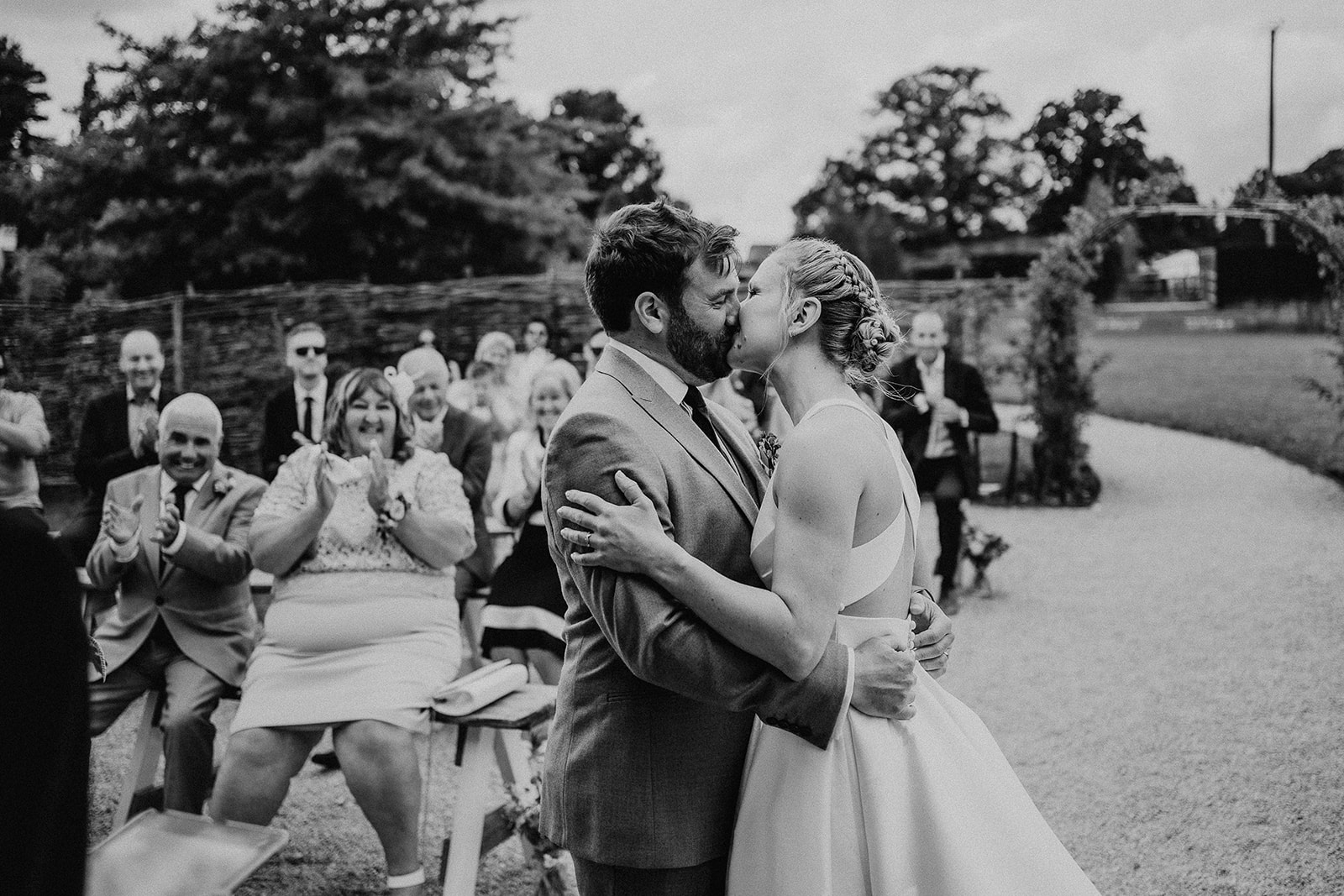 Black and white photo of the first kiss at a summer wedding at Silchester Farm