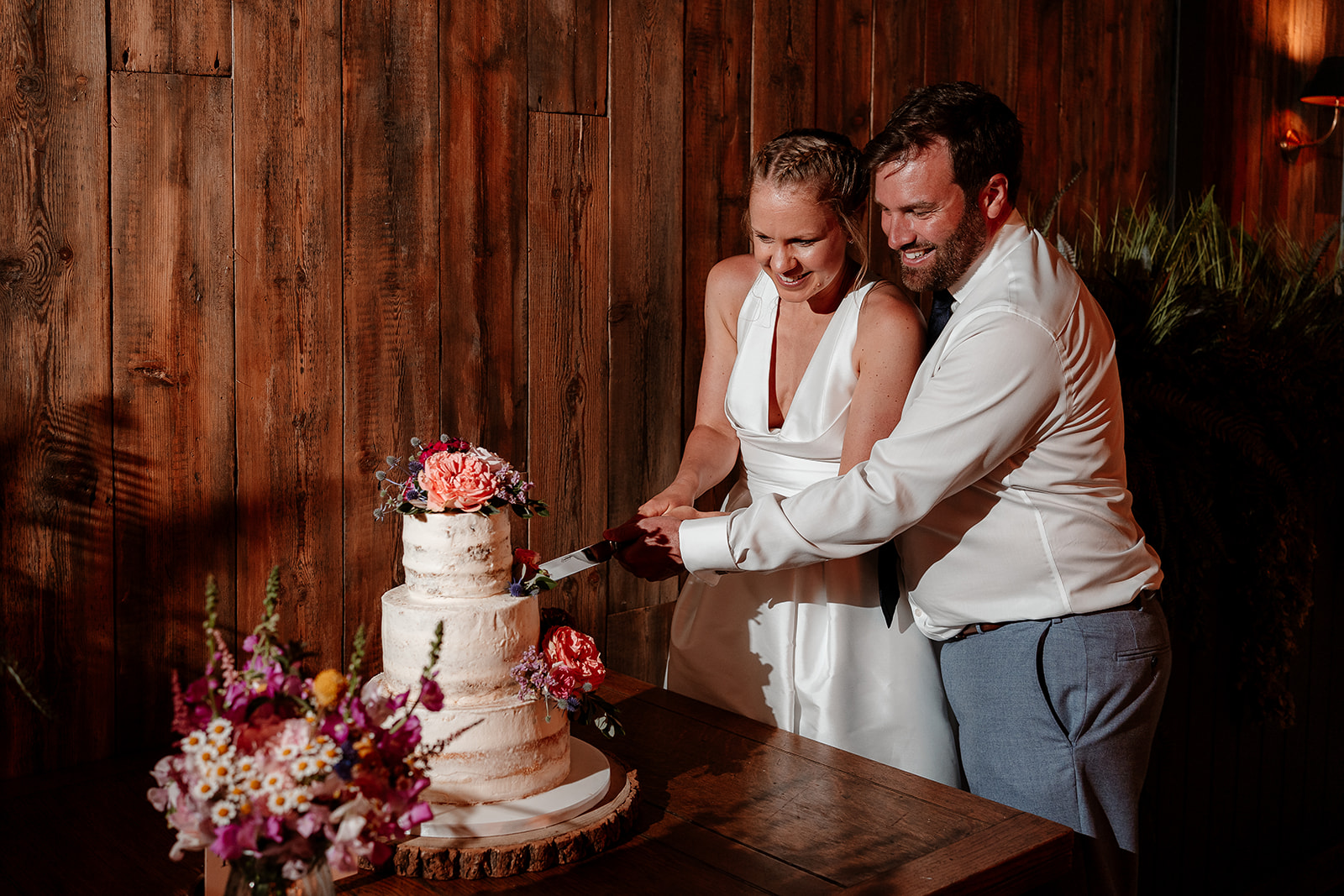 Bride and groom cut their cake at a summer wedding at Silchester Farm