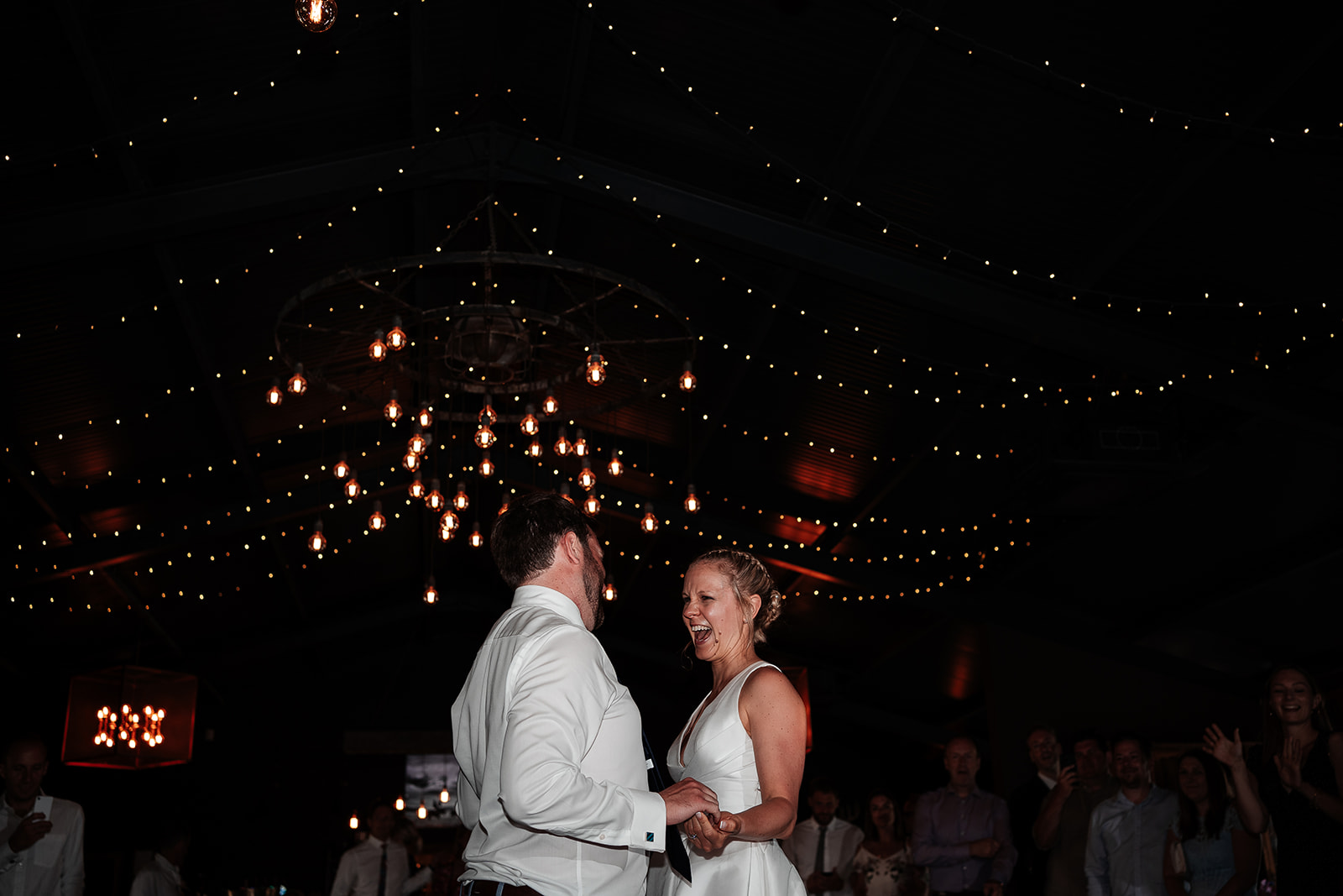Bride and groom laugh together during their first dance at a summer wedding at Silchester Farm