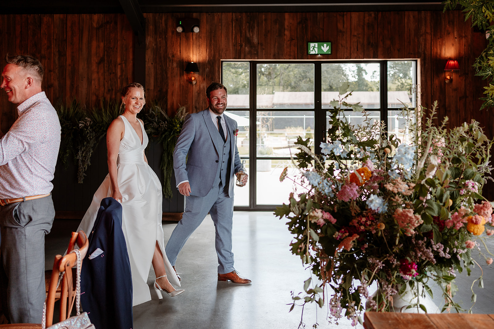 Bride and groom walk into their wedding breakfast together at a summer wedding at Silchester Farm