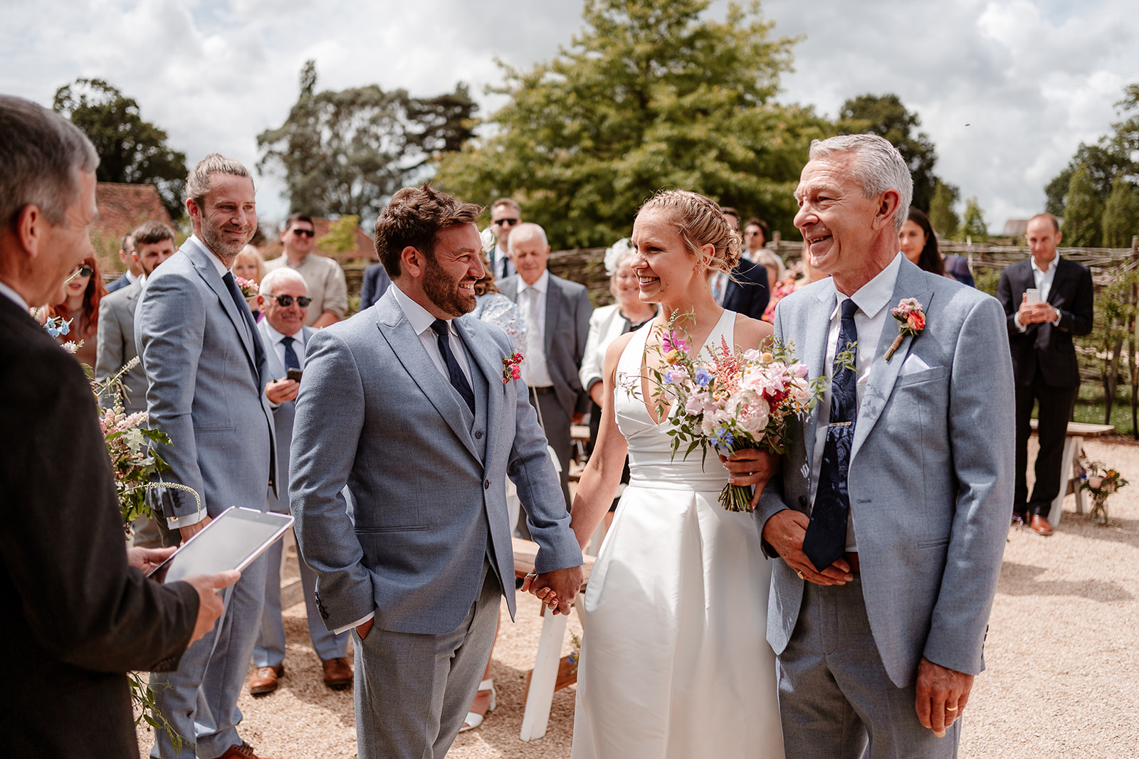 Bride and her father reach the top of the aisle and meet the groom at a summer wedding at Silchester Farm