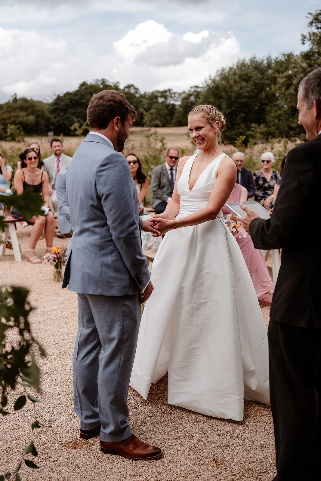 Bride puts a wedding ring on her groom at a summer wedding at Silchester Farm