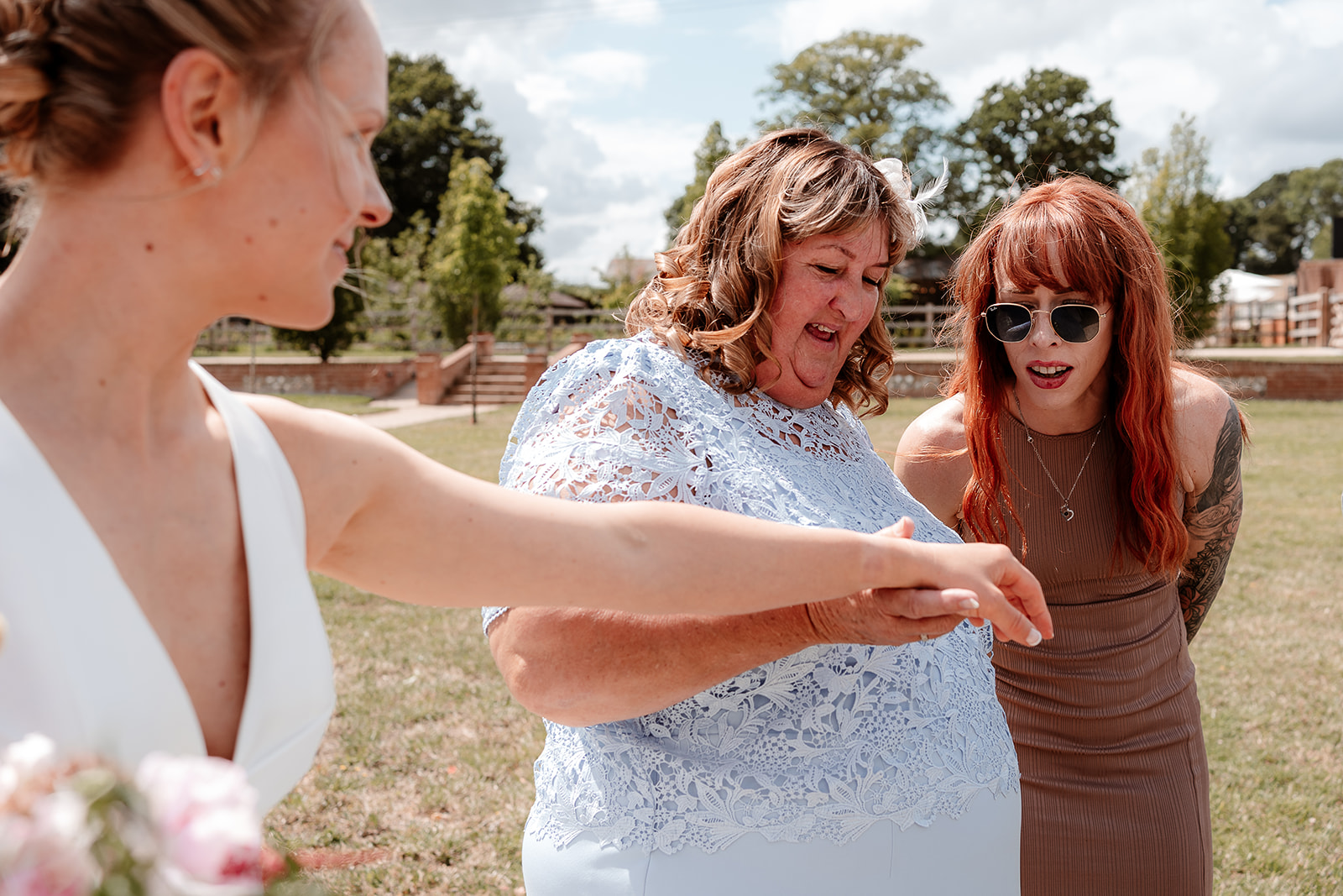 Bride shows off her ring to some guests at a summer wedding at Silchester Farm