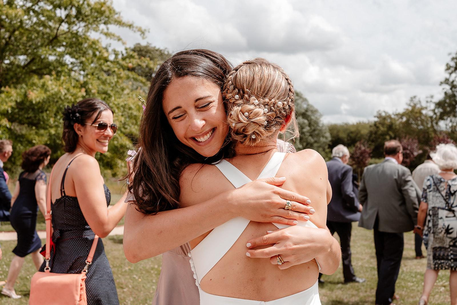 Guest gives the bride a big hug at a summer wedding at Silchester Farm