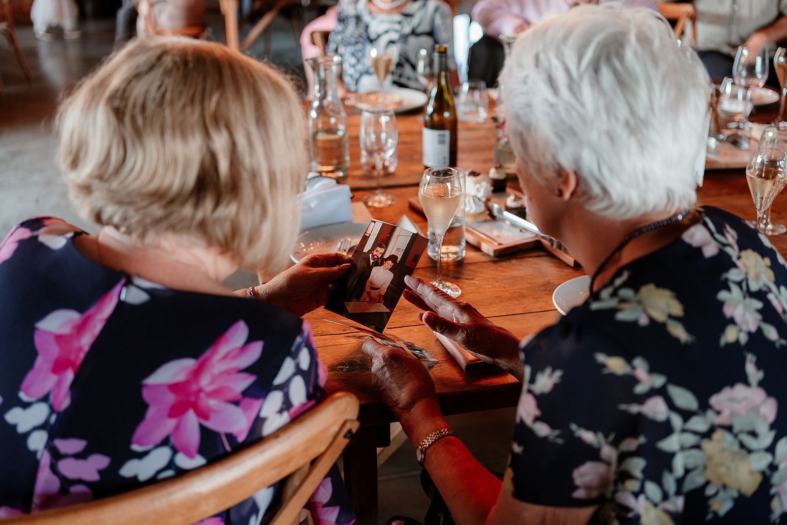 Guests look at each other's personalised messages from the bride and groom at a summer wedding at Silchester Farm