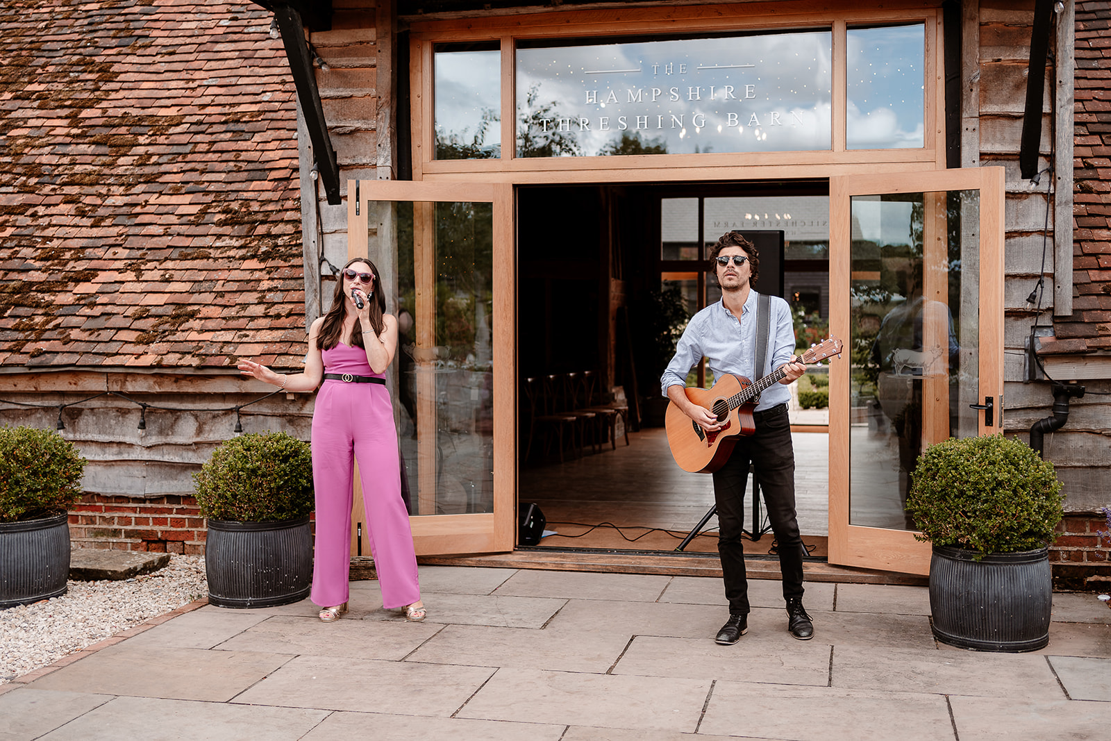 Musical duet of a singer and guitarist play during the reception at a summer wedding at Silchester Farm