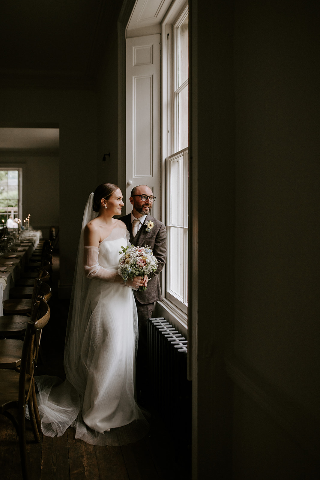 bride and groom looking out of window at aswarby rectory