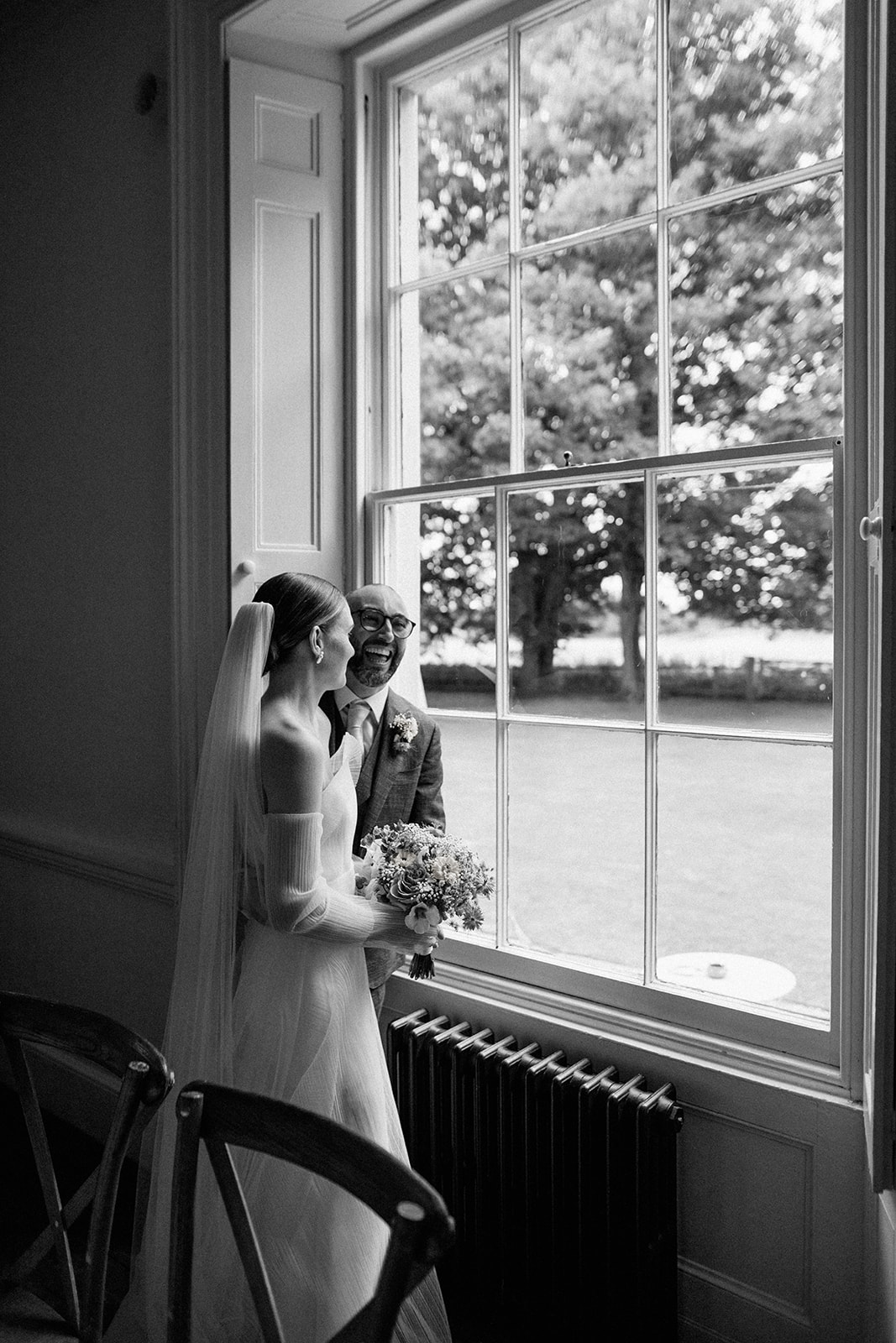 bride and groom looking out of window at aswarby rectory