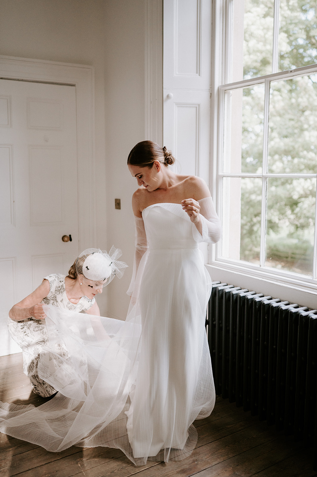 brides mum helping bride with dress at aswarby rectory