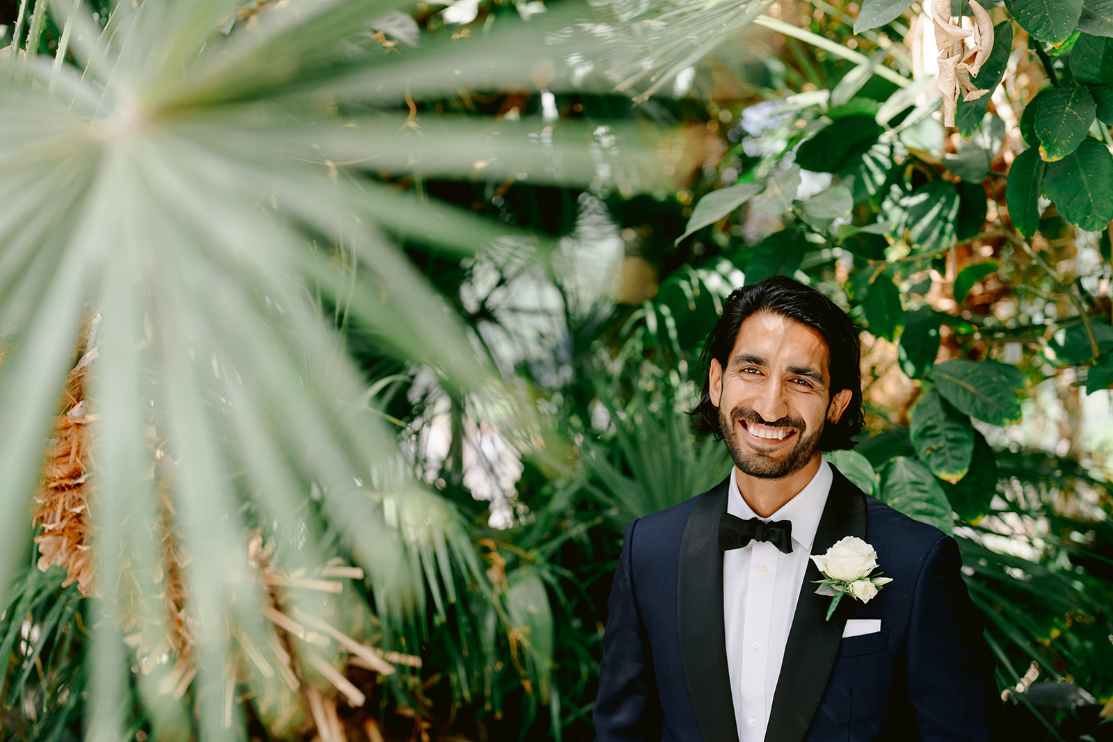 portrait of the groom with palm leaves at sefton park palm house