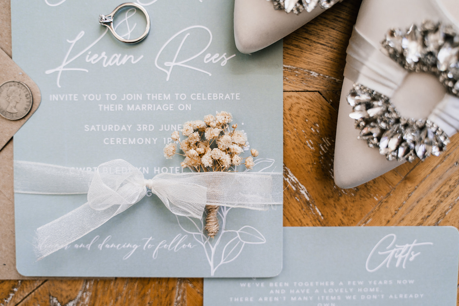 Wedding detail flat-lay including wedding invite and bridal jewellery