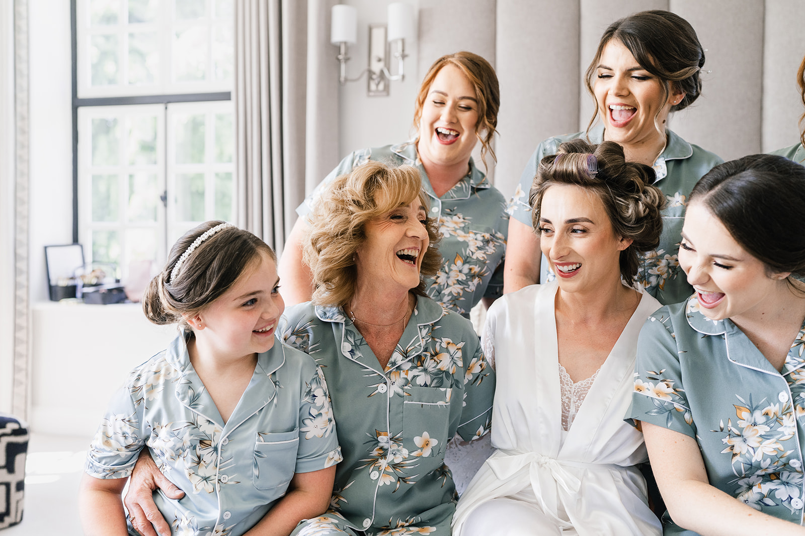 Bridal prep, bridesmaids laughing on the bed